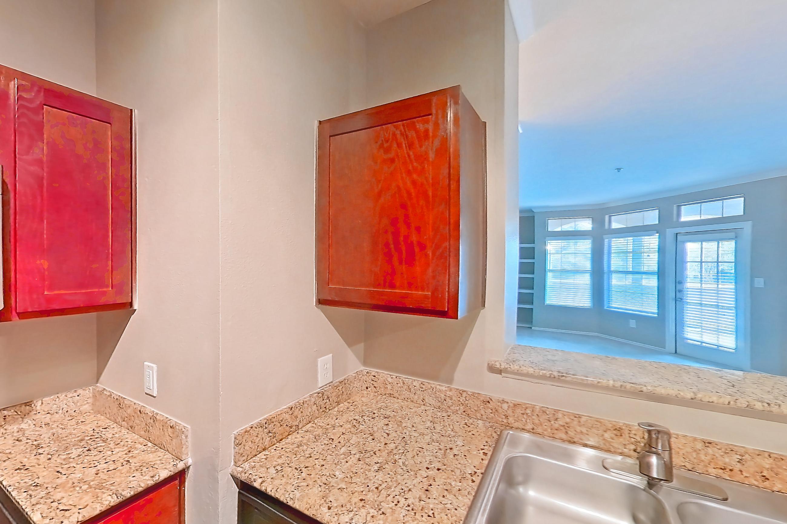 Kitchen with dishwasher, electric range, light stone countertops, light wood-finish flooring, microwave, oven/range, refrigerator, and stainless steel appliances, Apartment 0214 at Marquis at Barton Trails I