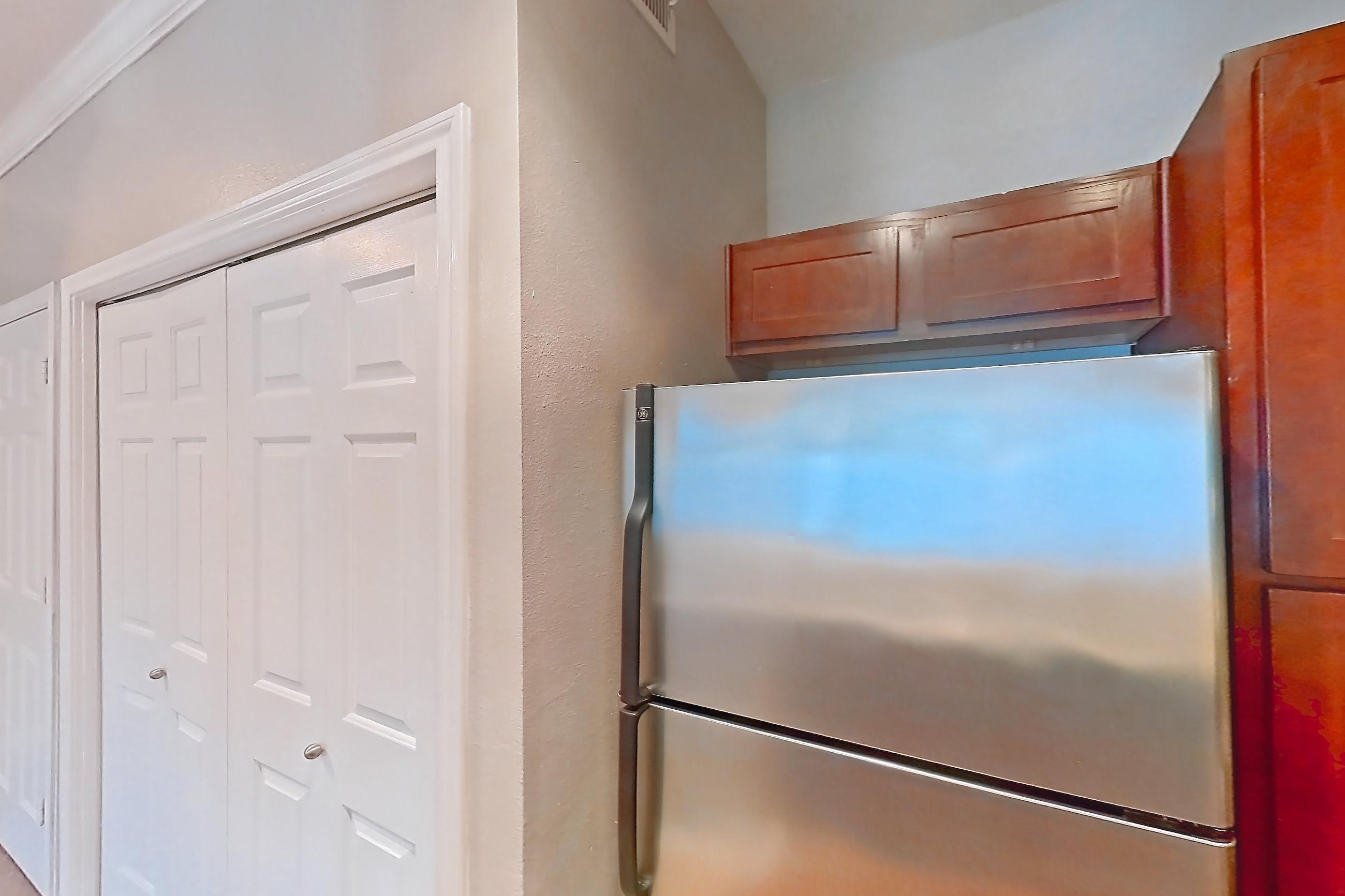 Kitchen with dishwasher, electric range, light stone countertops, light wood-finish flooring, microwave, oven/range, refrigerator, and stainless steel appliances, Apartment 0214 at Marquis at Barton Trails I