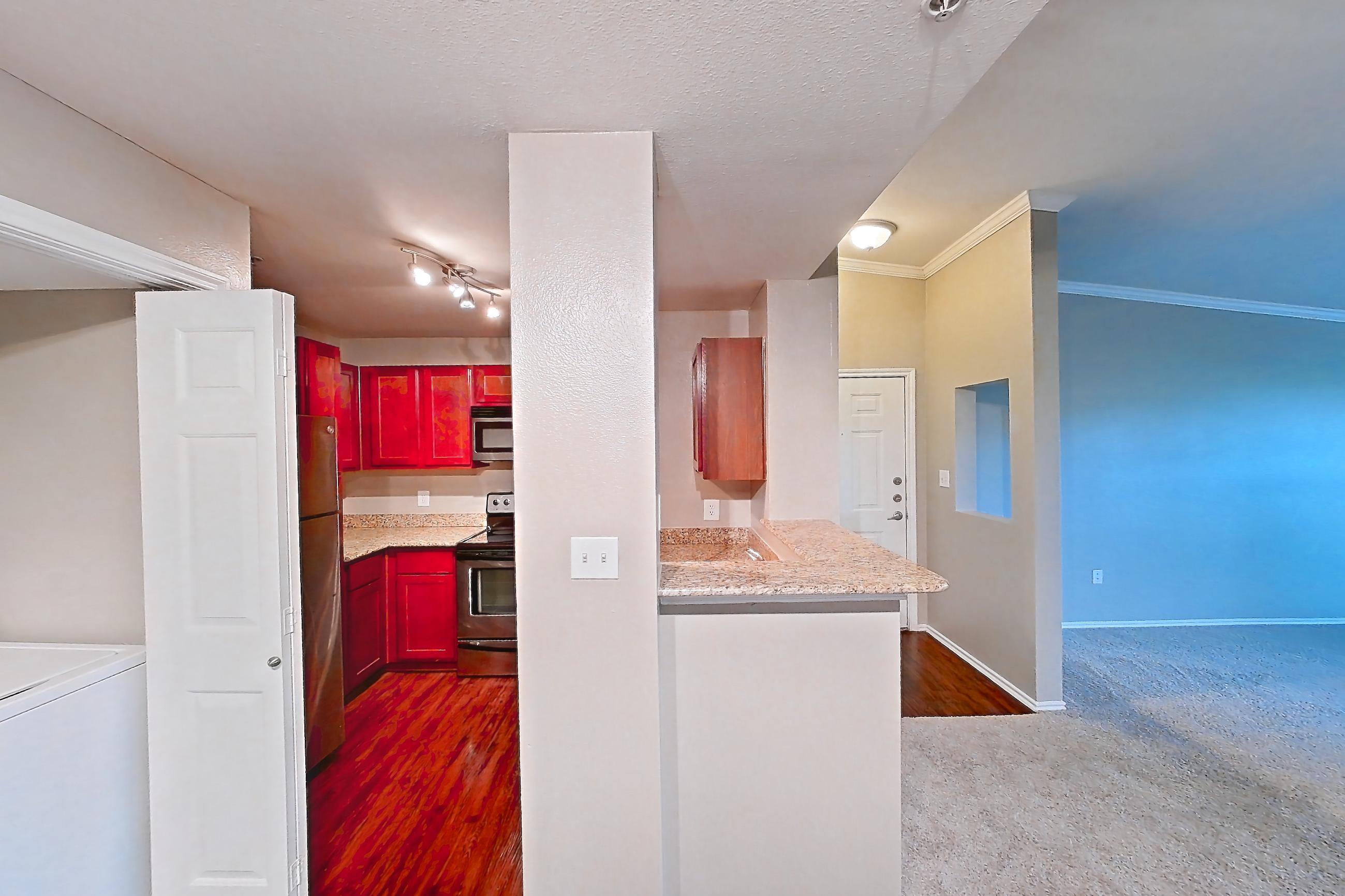 Dining room with dark carpet, electric range, in-unit laundry, oven/range, and stainless steel appliances, Apartment 0309 at Marquis at Barton Trails I