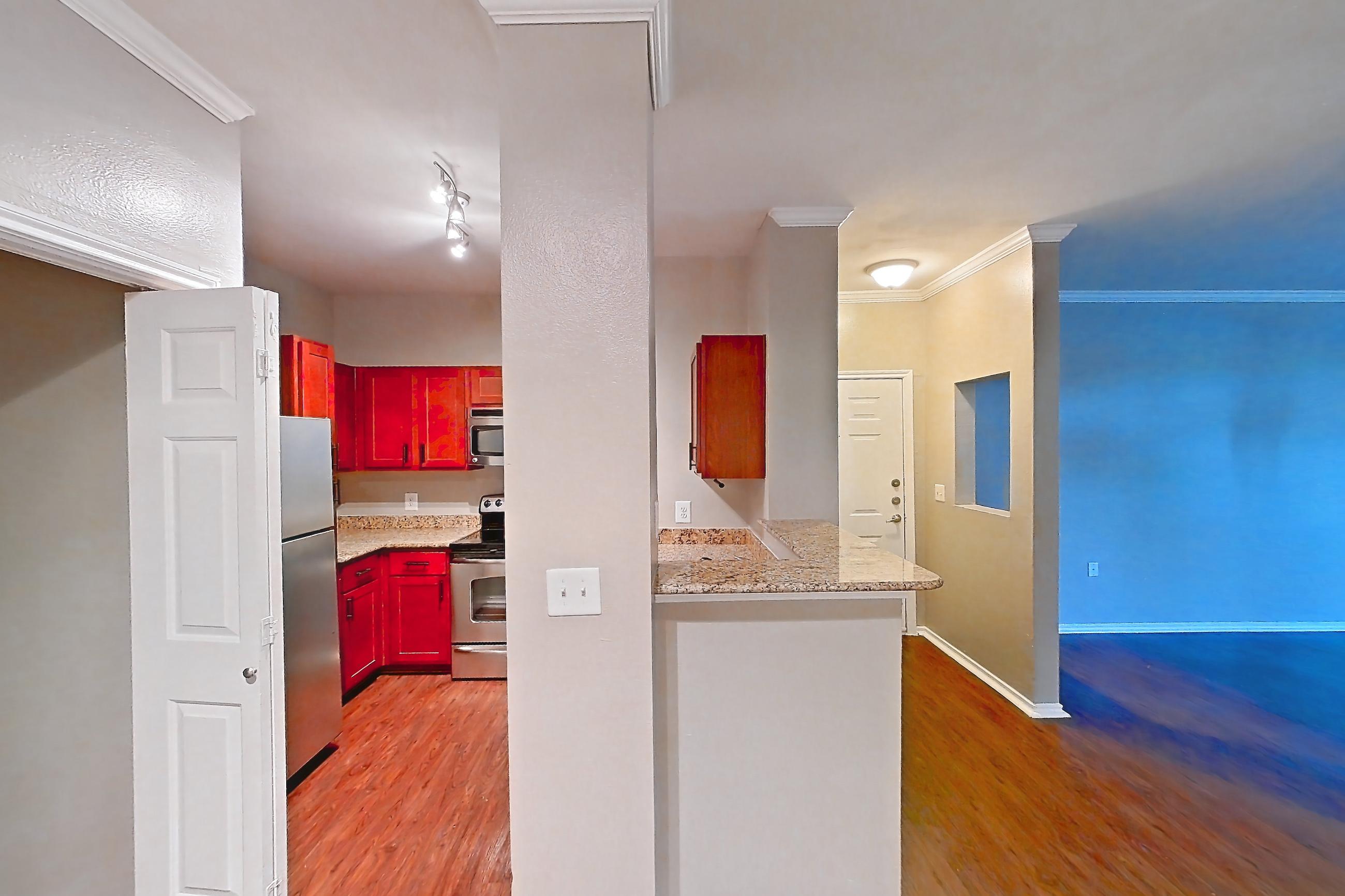 Dining room with dark wood-finish flooring, electric range, in-unit laundry, oven/range, refrigerator, and stainless steel appliances, Apartment 0613 at Marquis at Barton Trails I