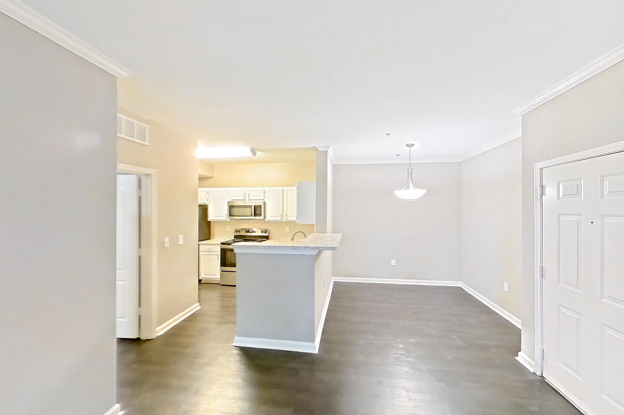 Living room with dark wood-finish flooring, electric range, light countertops, oven/range, and stainless steel appliances, Apartment 0209 at The Marq at Brookhaven