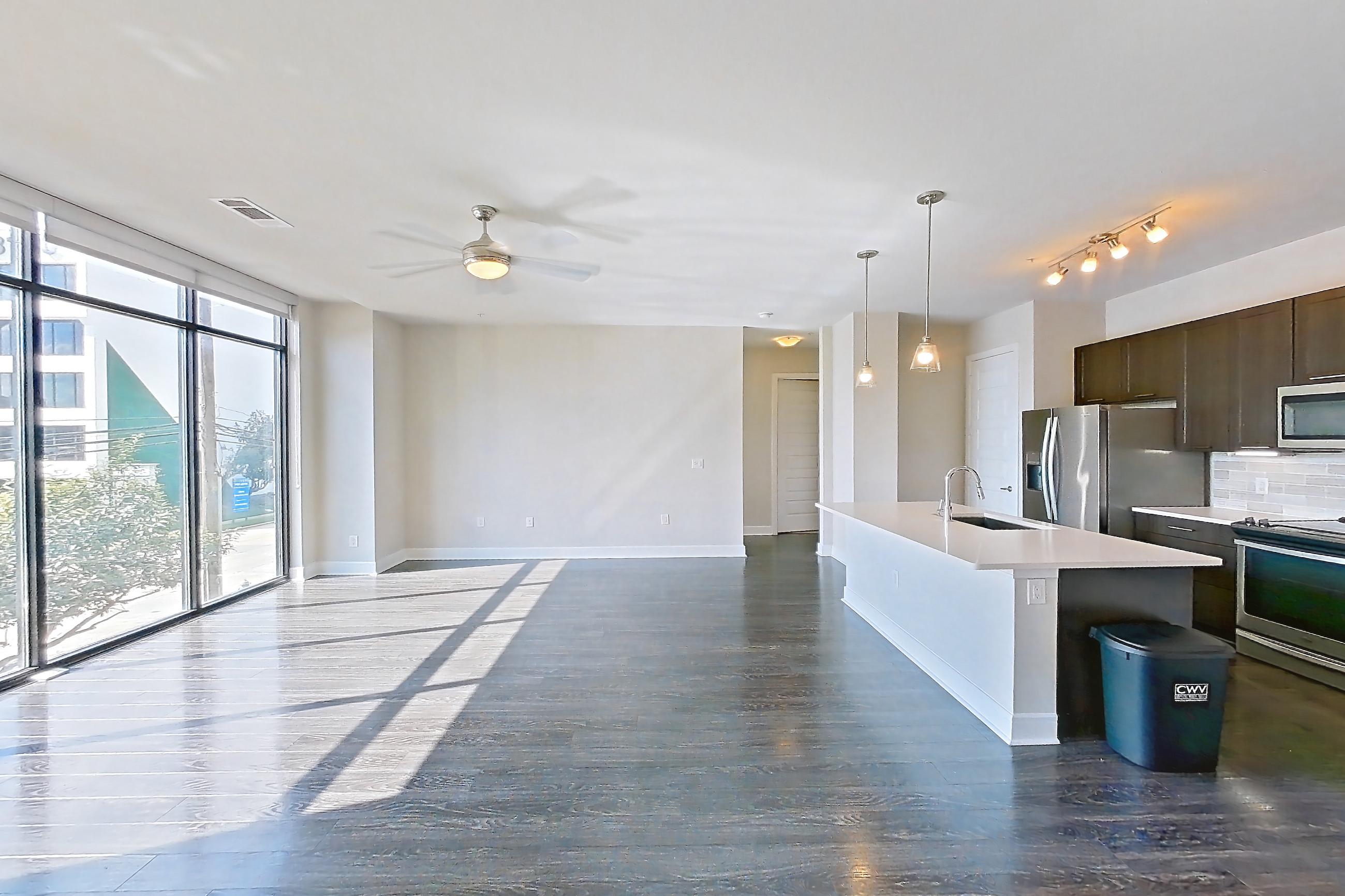 Living space with dark wood-finish flooring, kitchen island, and light stone countertops, Apartment 2231 at Marq 31