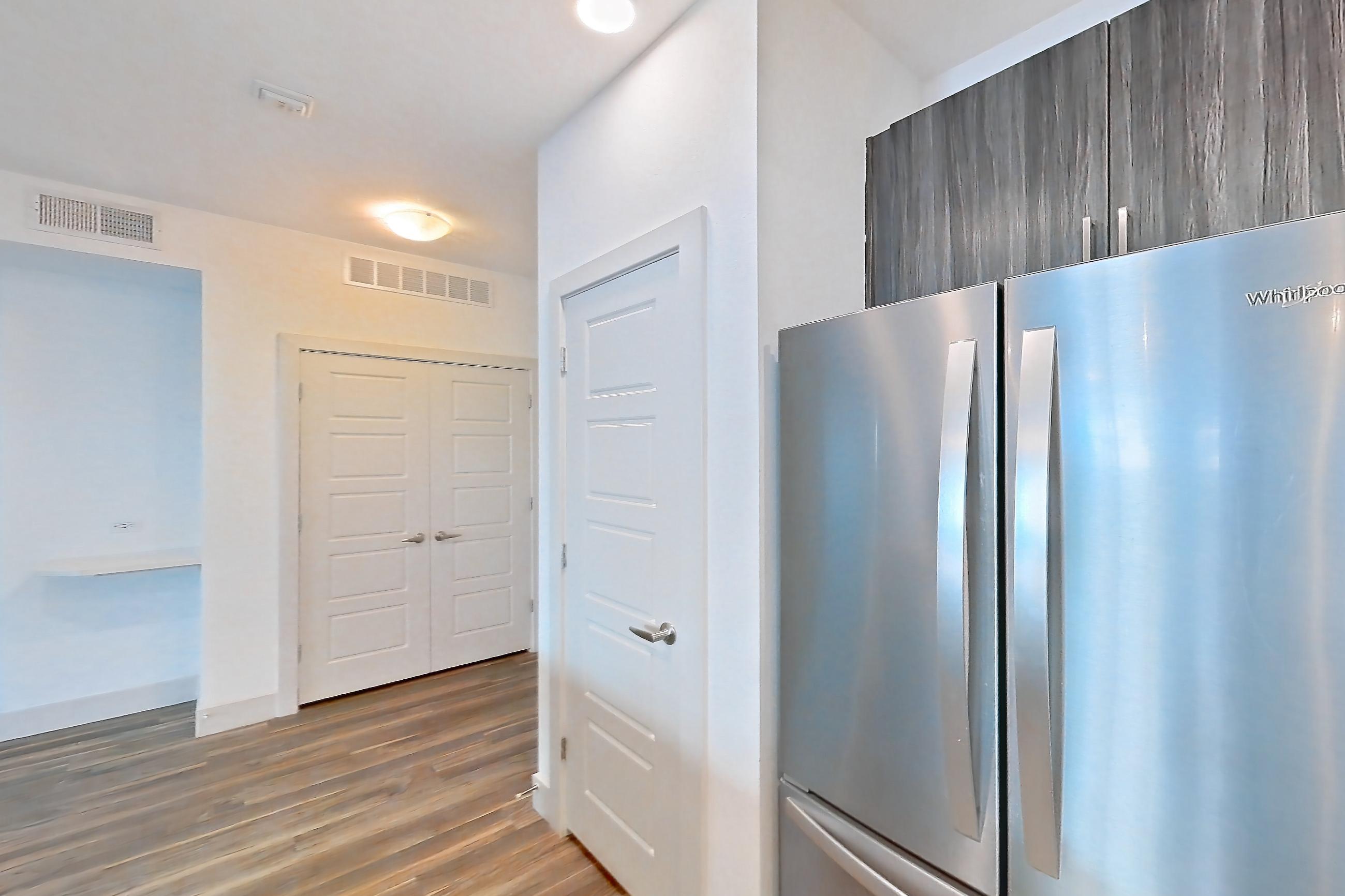 Kitchen with dishwasher, electric range, light countertops, microwave, oven/range, refrigerator, and stainless steel appliances, Apartment 1026 at Marquis at Chandler