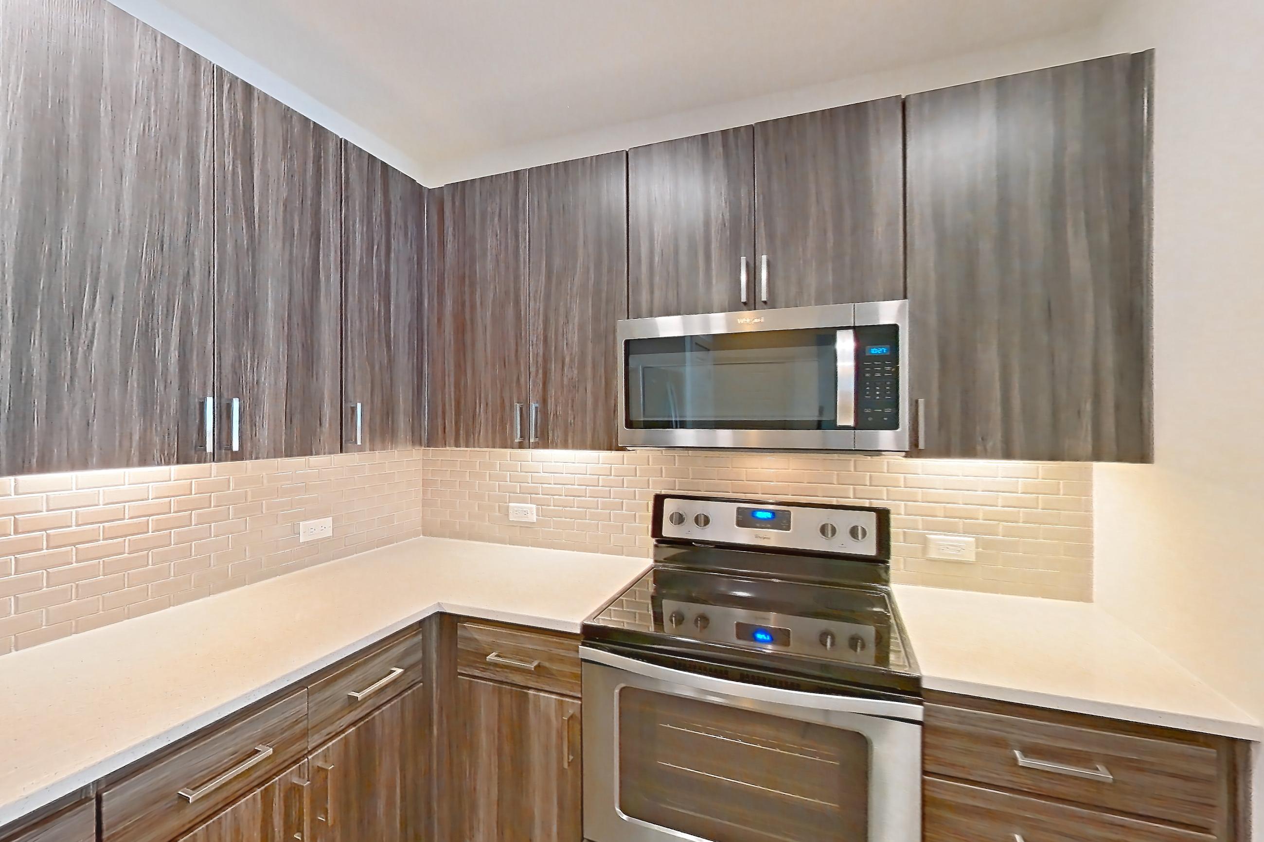 Kitchen with dishwasher, electric range, light countertops, microwave, oven/range, refrigerator, and stainless steel appliances, Apartment 1026 at Marquis at Chandler