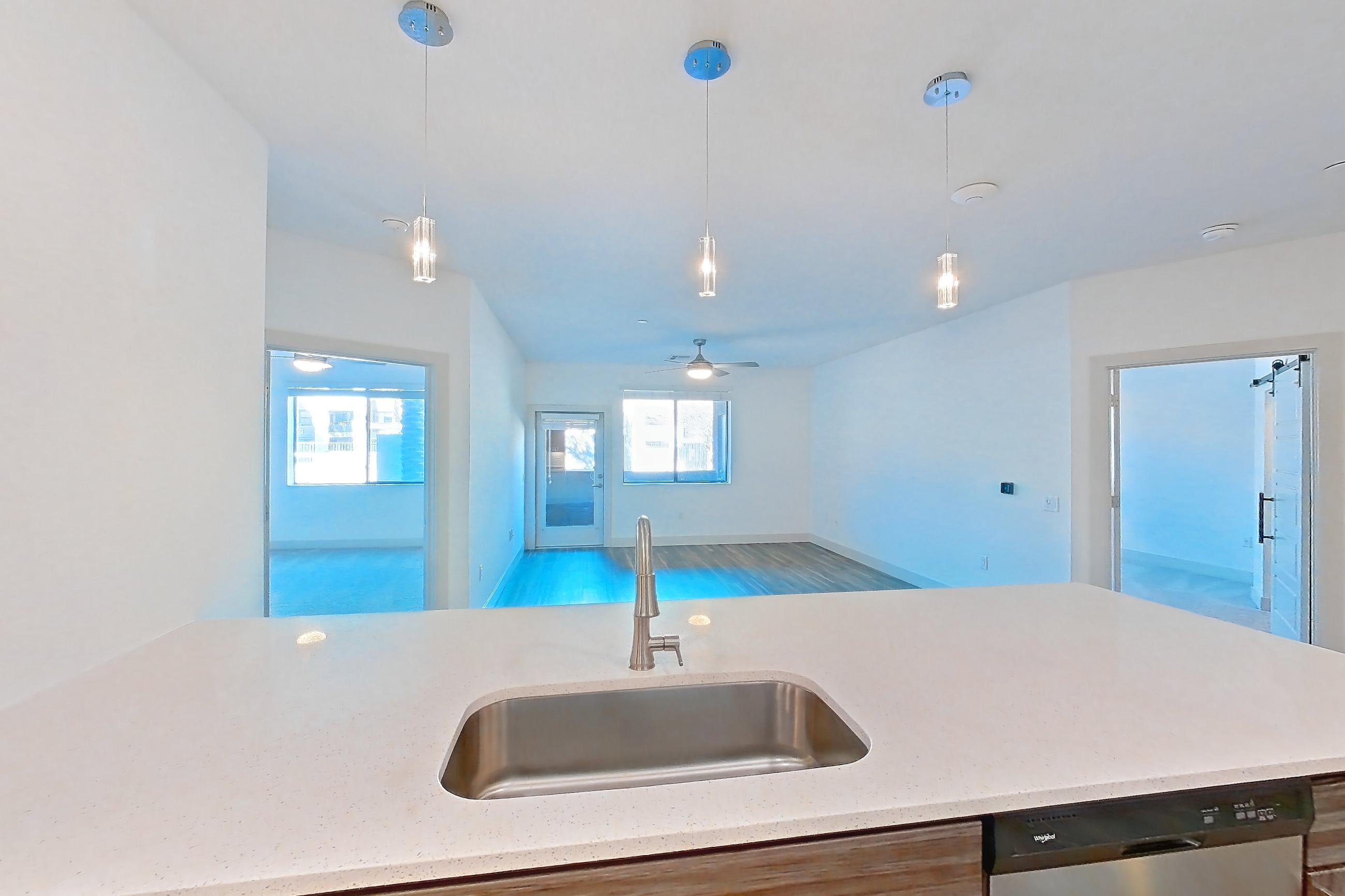 Kitchen with dishwasher, electric range, light countertops, microwave, oven/range, refrigerator, and stainless steel appliances, Apartment 1026 at Marquis at Chandler