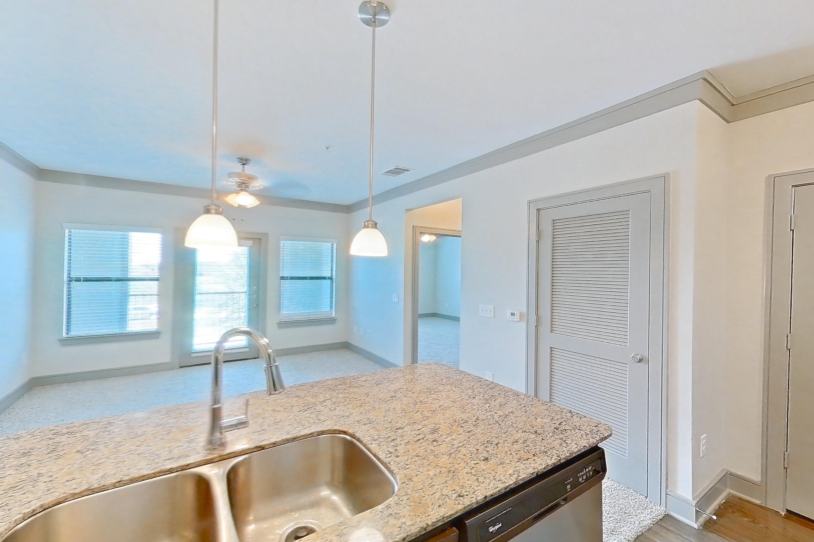 Kitchen with dishwasher, electric range, light stone countertops, light wood-finish flooring, oven/range, refrigerator, and stainless steel appliances, Apartment 1210 at Marquis Seven Meadows