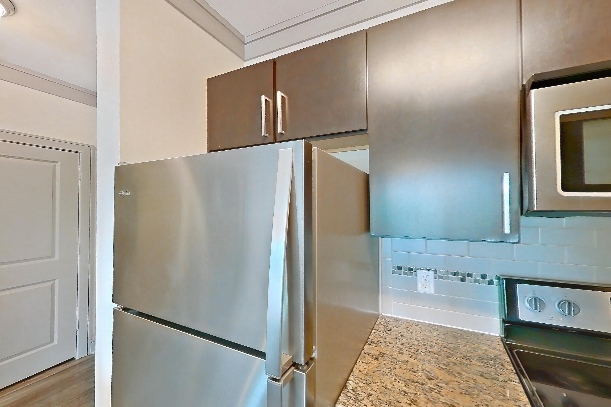 Kitchen with dishwasher, electric range, light stone countertops, light wood-finish flooring, oven/range, refrigerator, and stainless steel appliances, Apartment 1210 at Marquis Seven Meadows