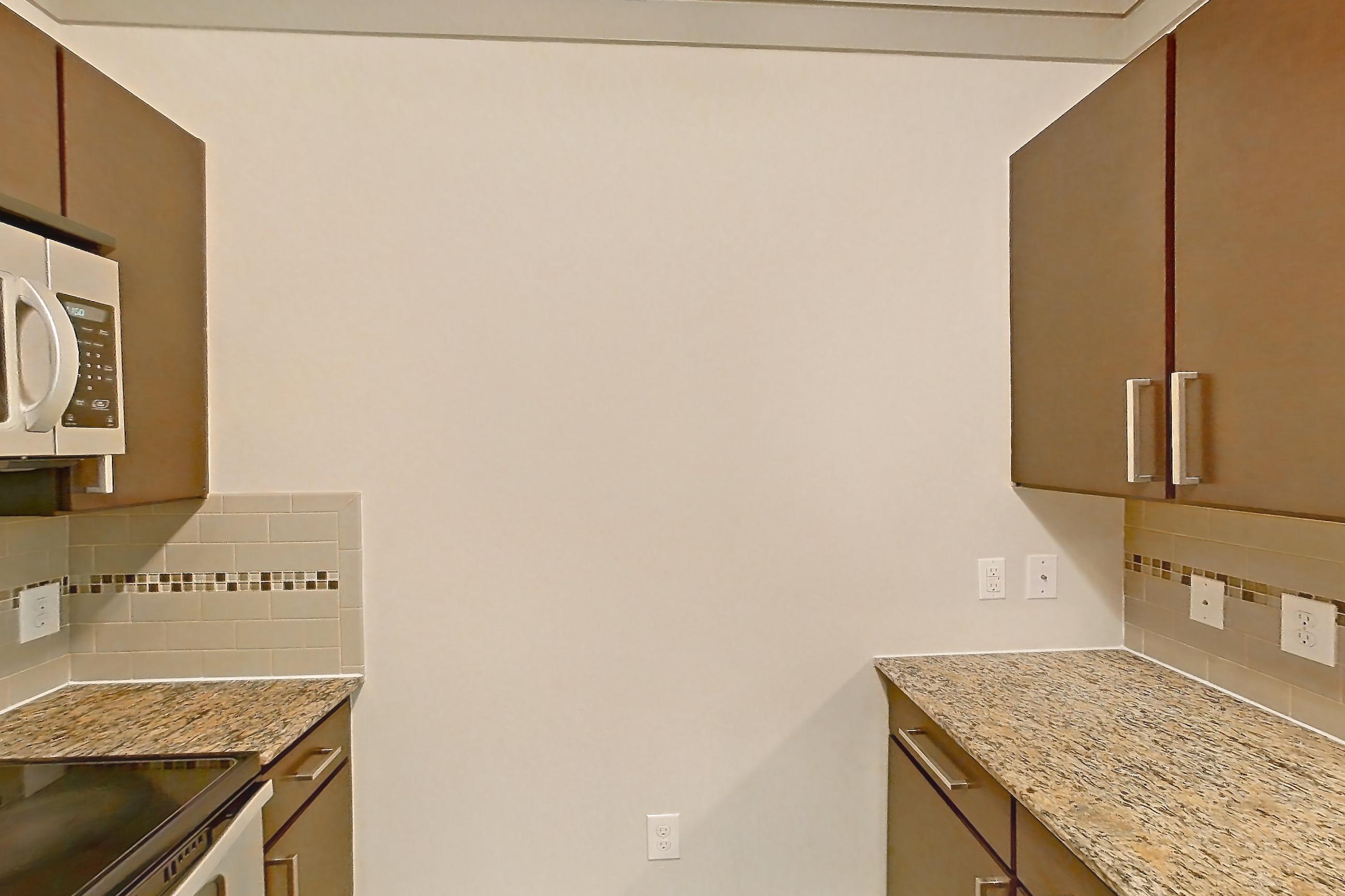 Kitchen with dishwasher, electric range, light stone countertops, light wood-finish flooring, oven/range, refrigerator, and stainless steel appliances, Apartment 1210 at Marquis Seven Meadows