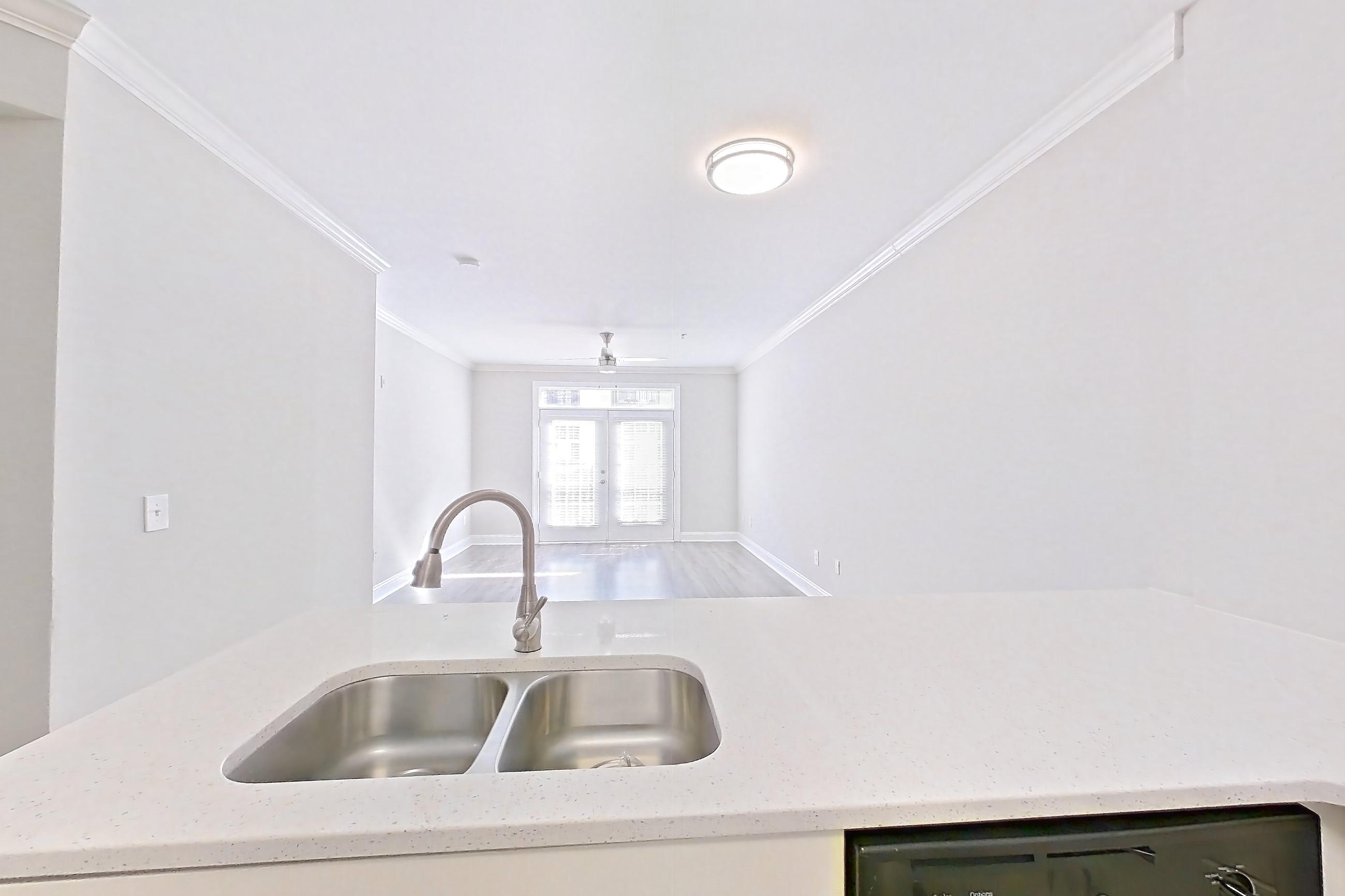 Kitchen with dishwasher, electric range, light countertops, light wood-finish flooring, microwave, oven/range, refrigerator, and stainless steel appliances, Apartment 2114 at Marq Perimeter