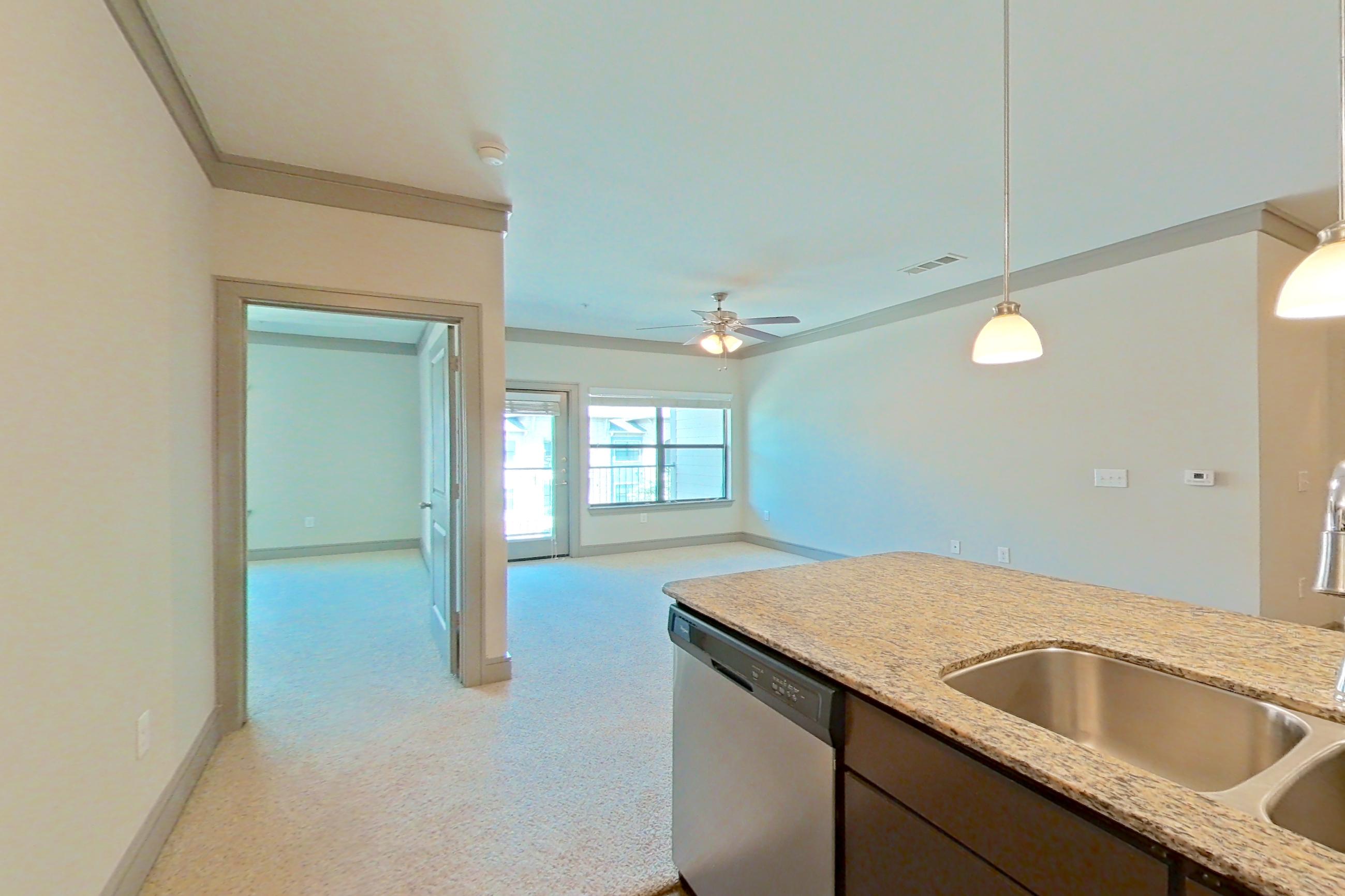 Kitchen with dishwasher, light stone countertops, refrigerator, and stainless steel appliances, Apartment 3309 at Marquis Seven Meadows