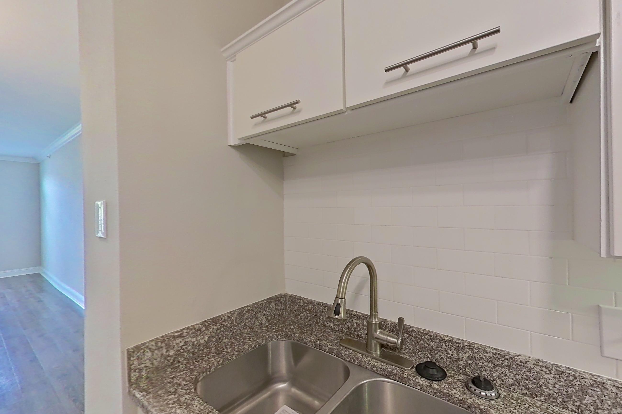 Kitchen with dark wood-finish flooring, electric range, light countertops, light stone countertops, microwave, oven/range, refrigerator, and stainless steel appliances, Apartment 2514 at Marq Perimeter