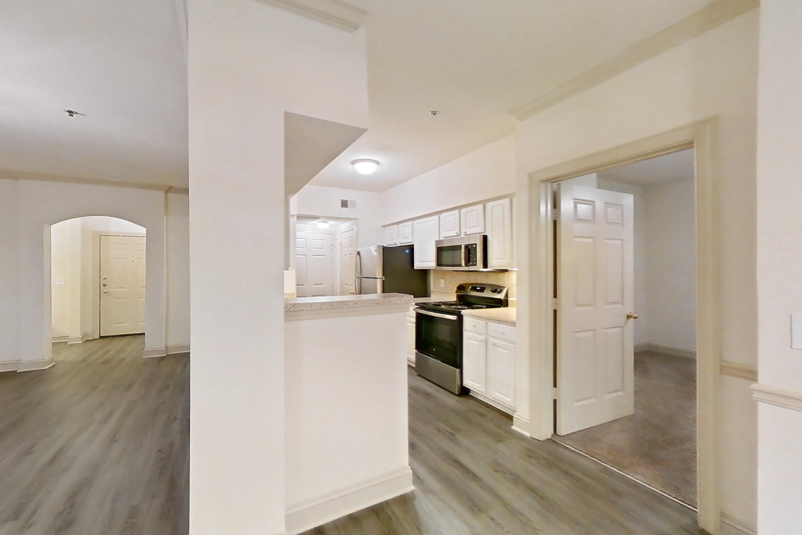 Dining room with dark wood-finish flooring, electric range, light countertops, light wood-finish flooring, microwave, oven/range, and stainless steel appliances, Apartment 3205 at Marq Perimeter
