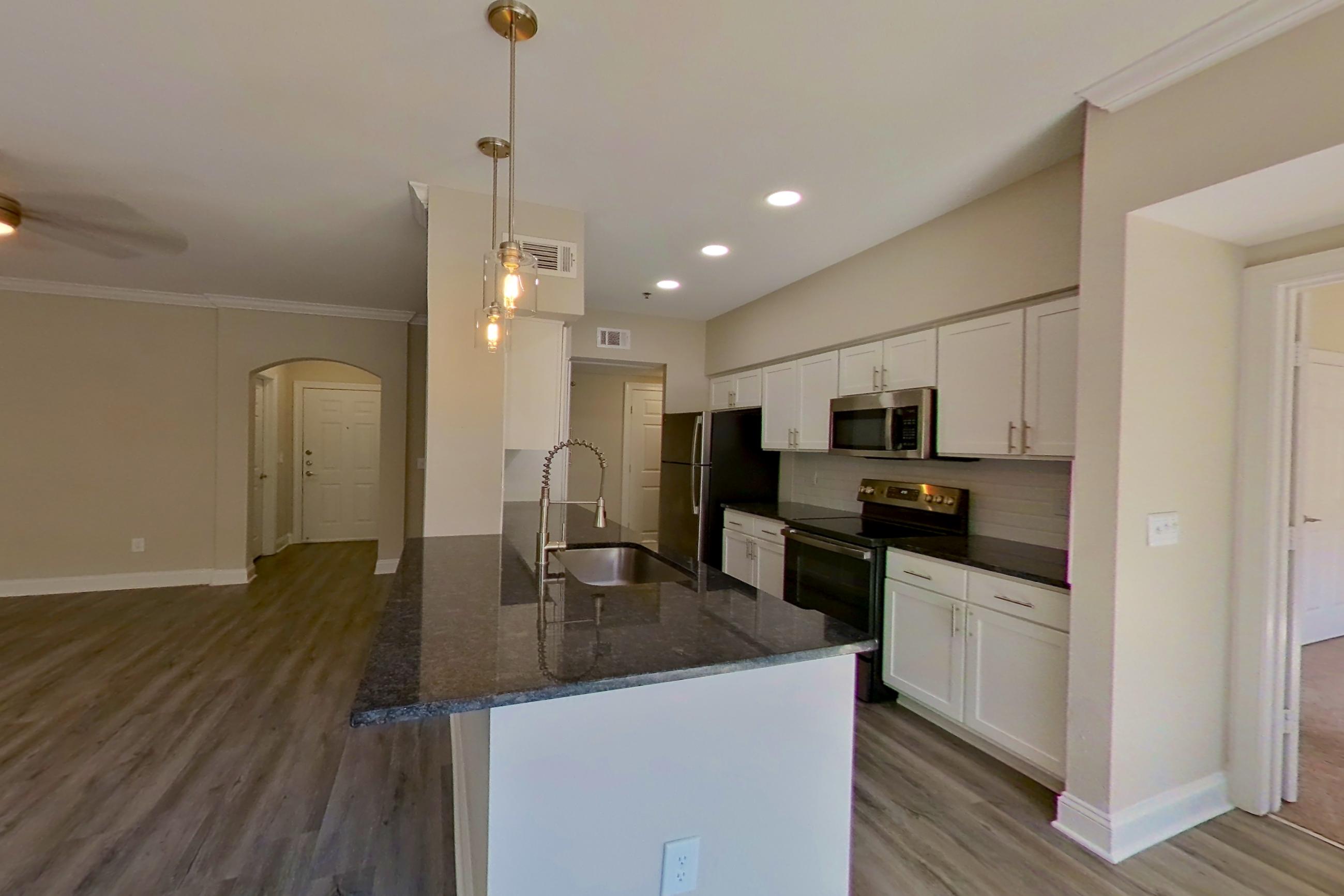 Dining area with dark stone countertops, electric range, light wood-finish flooring, oven/range, and stainless steel appliances, Apartment 3308 at Marq Perimeter