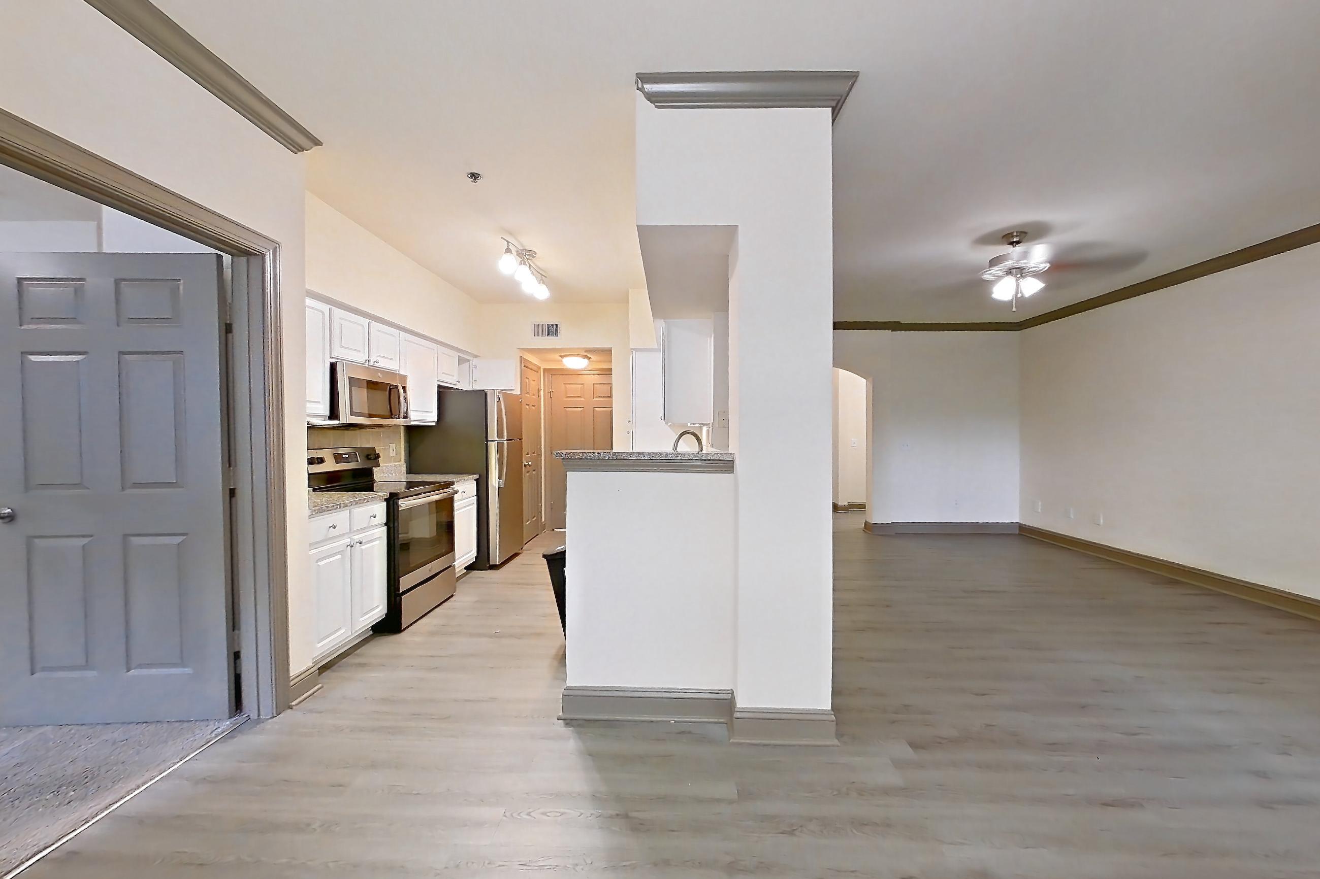 Dining room with electric range, light countertops, light wood-finish flooring, microwave, oven/range, refrigerator, and stainless steel appliances, Apartment 3311 at Marq Perimeter