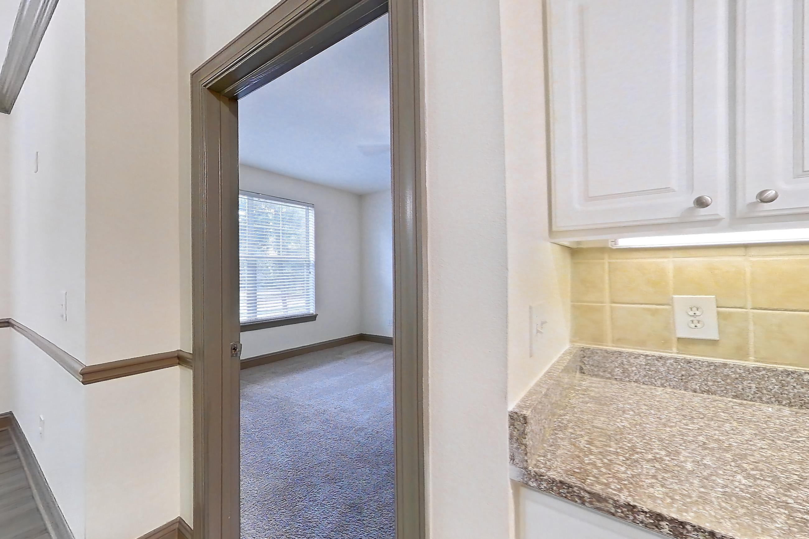Kitchen with dark stone countertops, dishwasher, electric range, light carpet, light countertops, light stone countertops, light wood-finish flooring, microwave, oven/range, refrigerator, and stainless steel appliances, Apartment 3311 at Marq Perimeter