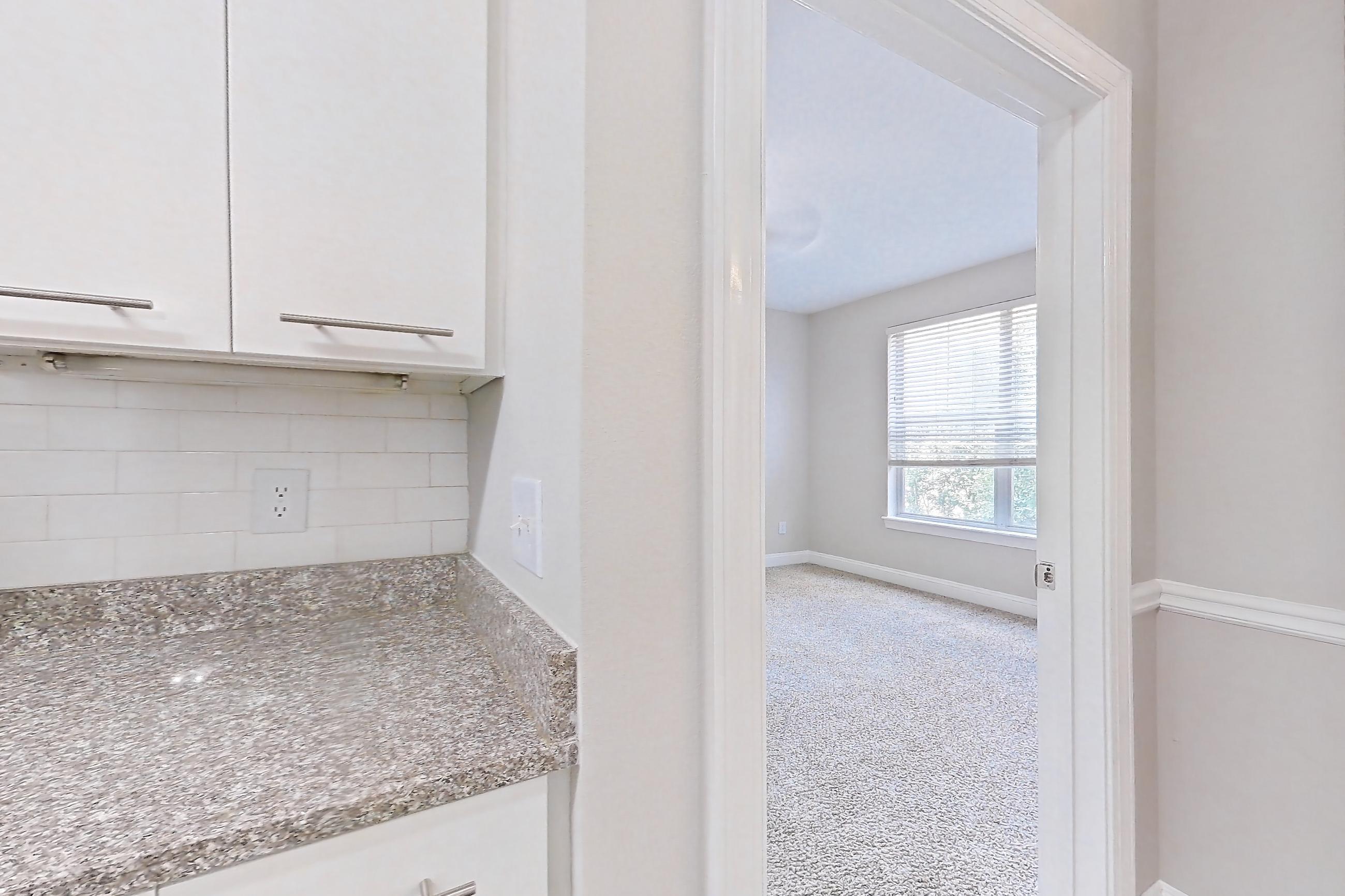 Kitchen with dark carpet, dark wood-finish flooring, dishwasher, electric range, light countertops, light stone countertops, microwave, oven/range, refrigerator, and stainless steel appliances, Apartment 3401 at Marq Perimeter