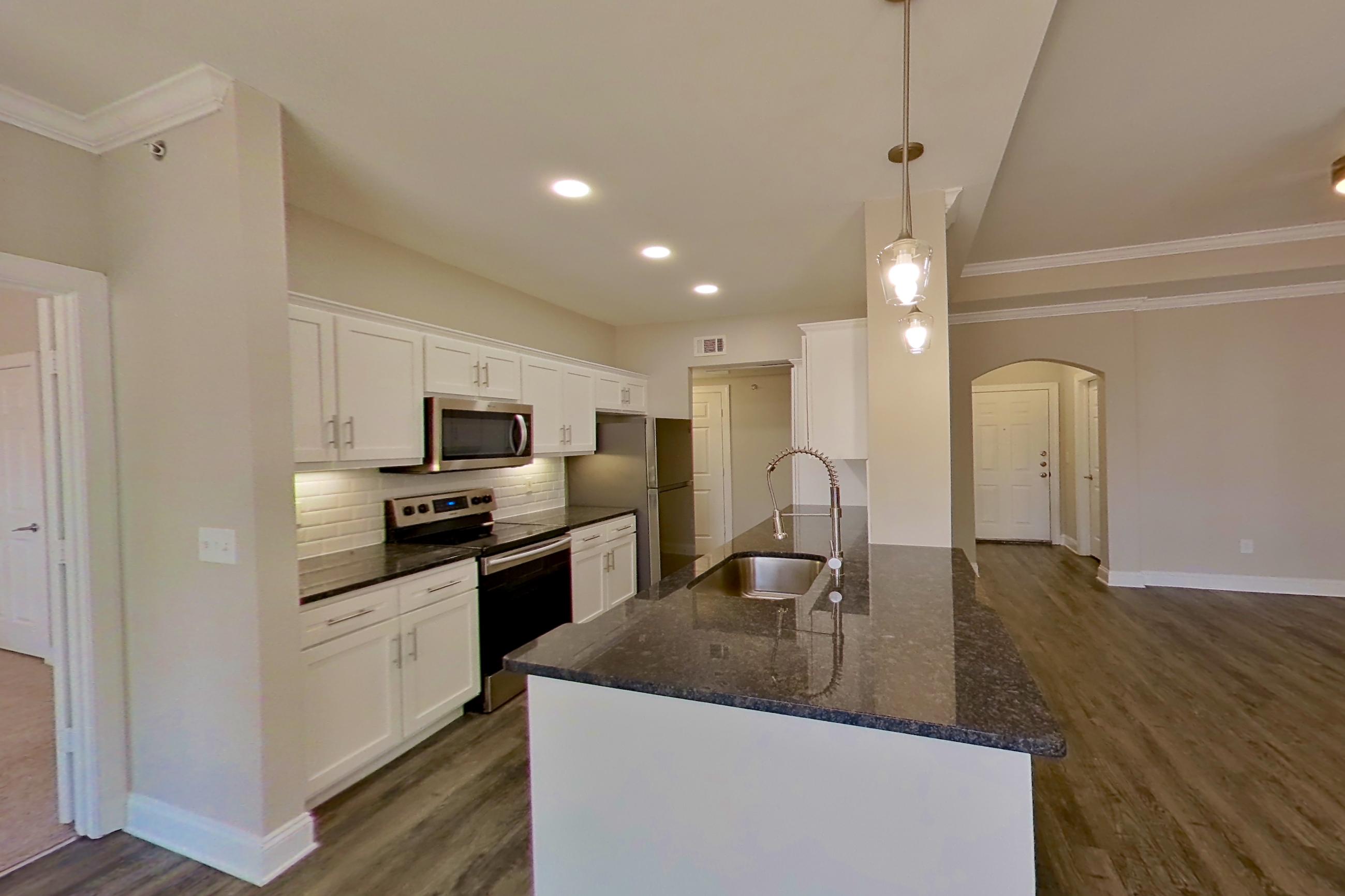 Dining area with dark stone countertops, dark wood-finish flooring, electric range, oven/range, refrigerator, and stainless steel appliances, Apartment 3509 at Marq Perimeter