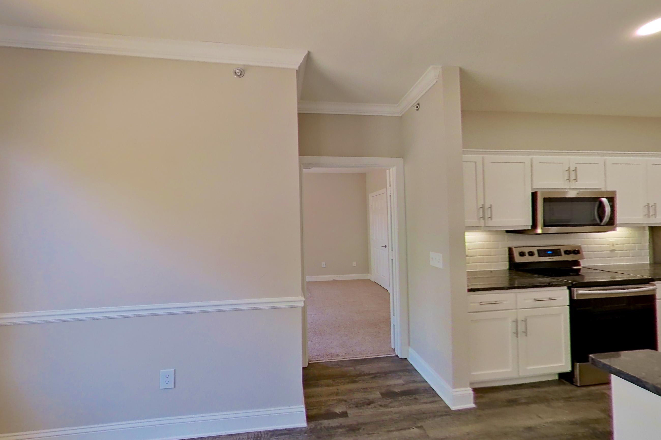 Dining area with dark stone countertops, dark wood-finish flooring, electric range, oven/range, refrigerator, and stainless steel appliances, Apartment 3509 at Marq Perimeter