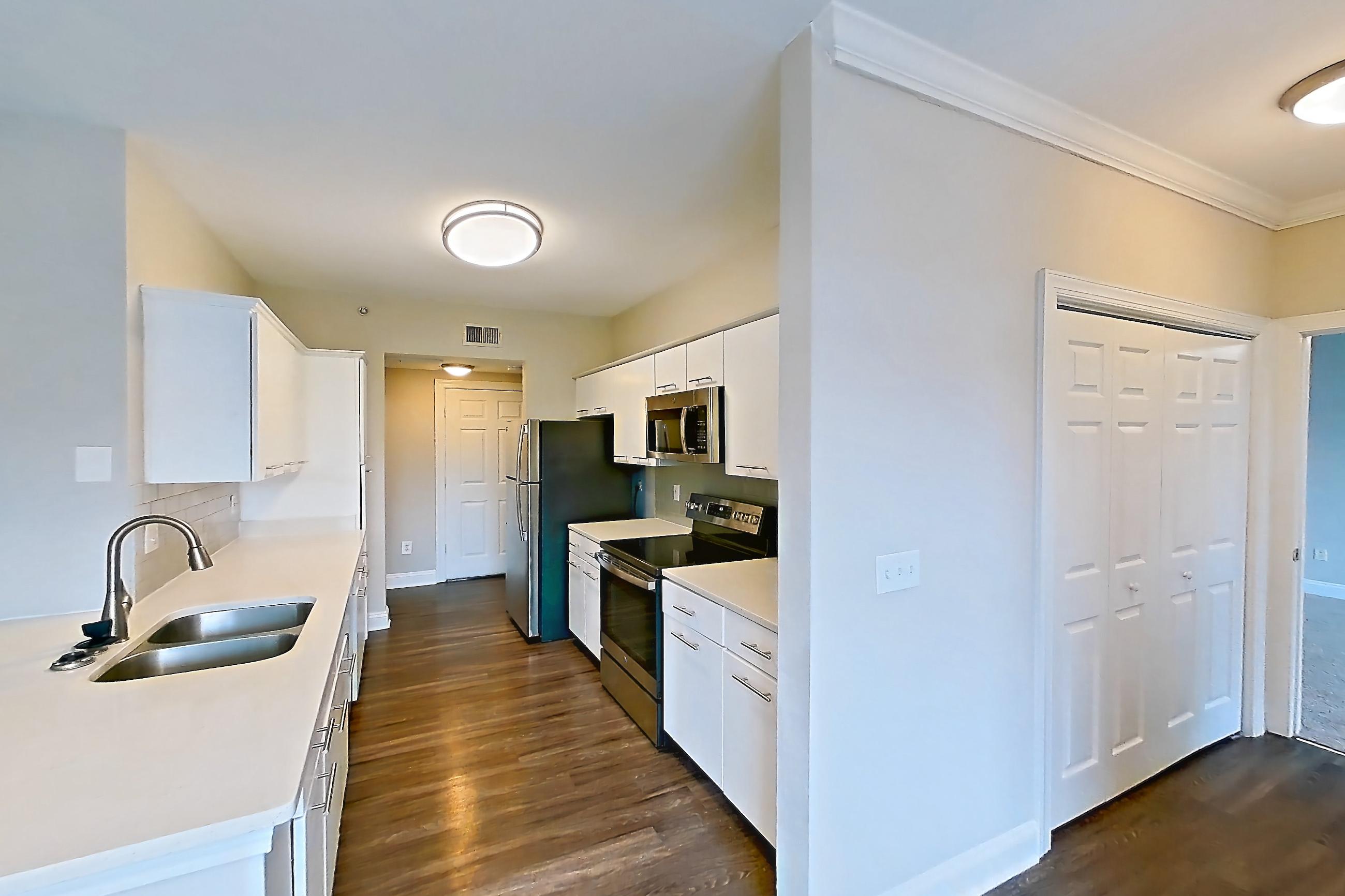 Dining room with dark wood-finish flooring, electric range, light countertops, light stone countertops, microwave, oven/range, refrigerator, and stainless steel appliances, Apartment 3515 at Marq Perimeter