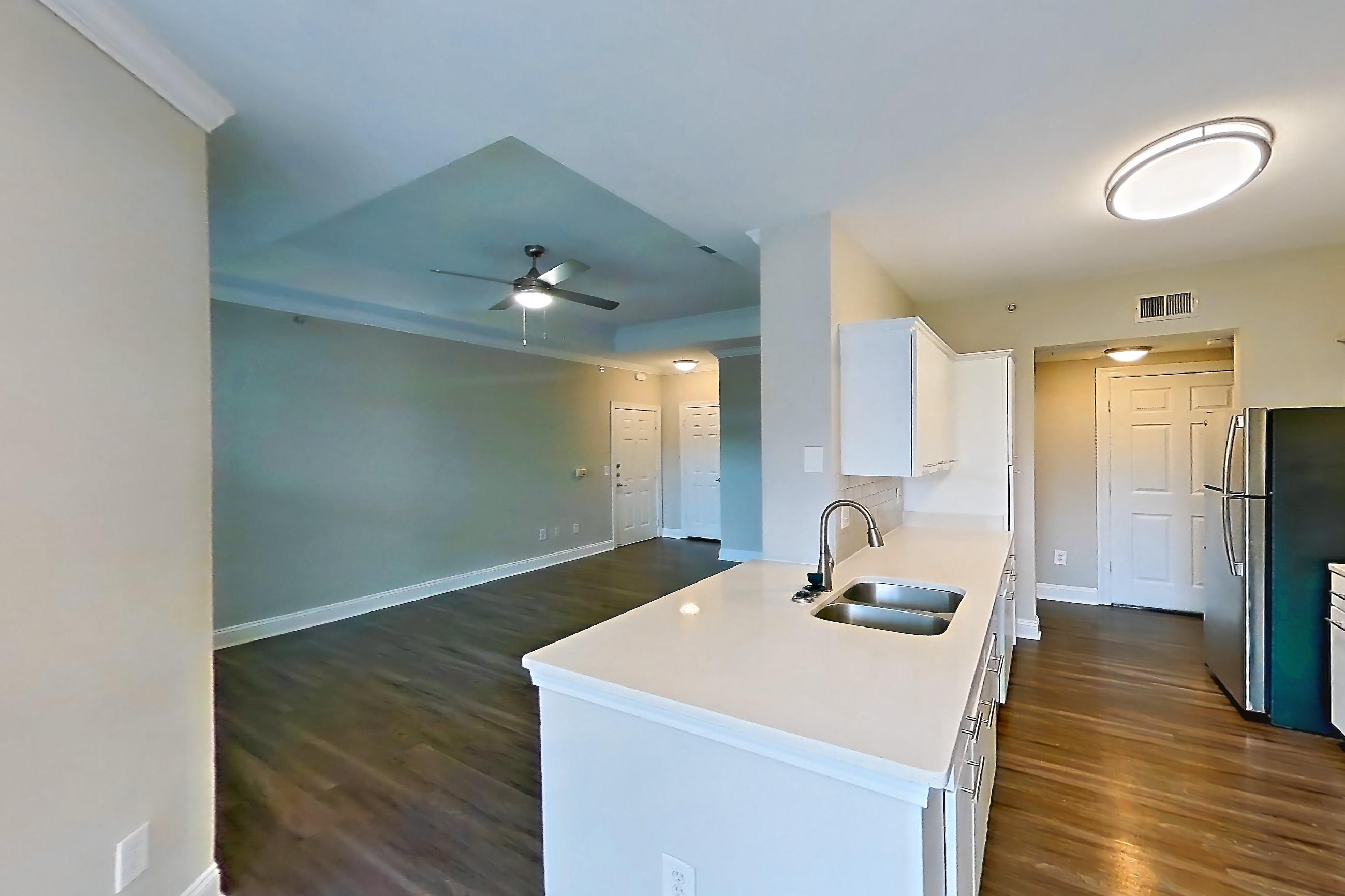 Dining room with dark wood-finish flooring, electric range, light countertops, light stone countertops, microwave, oven/range, refrigerator, and stainless steel appliances, Apartment 3515 at Marq Perimeter