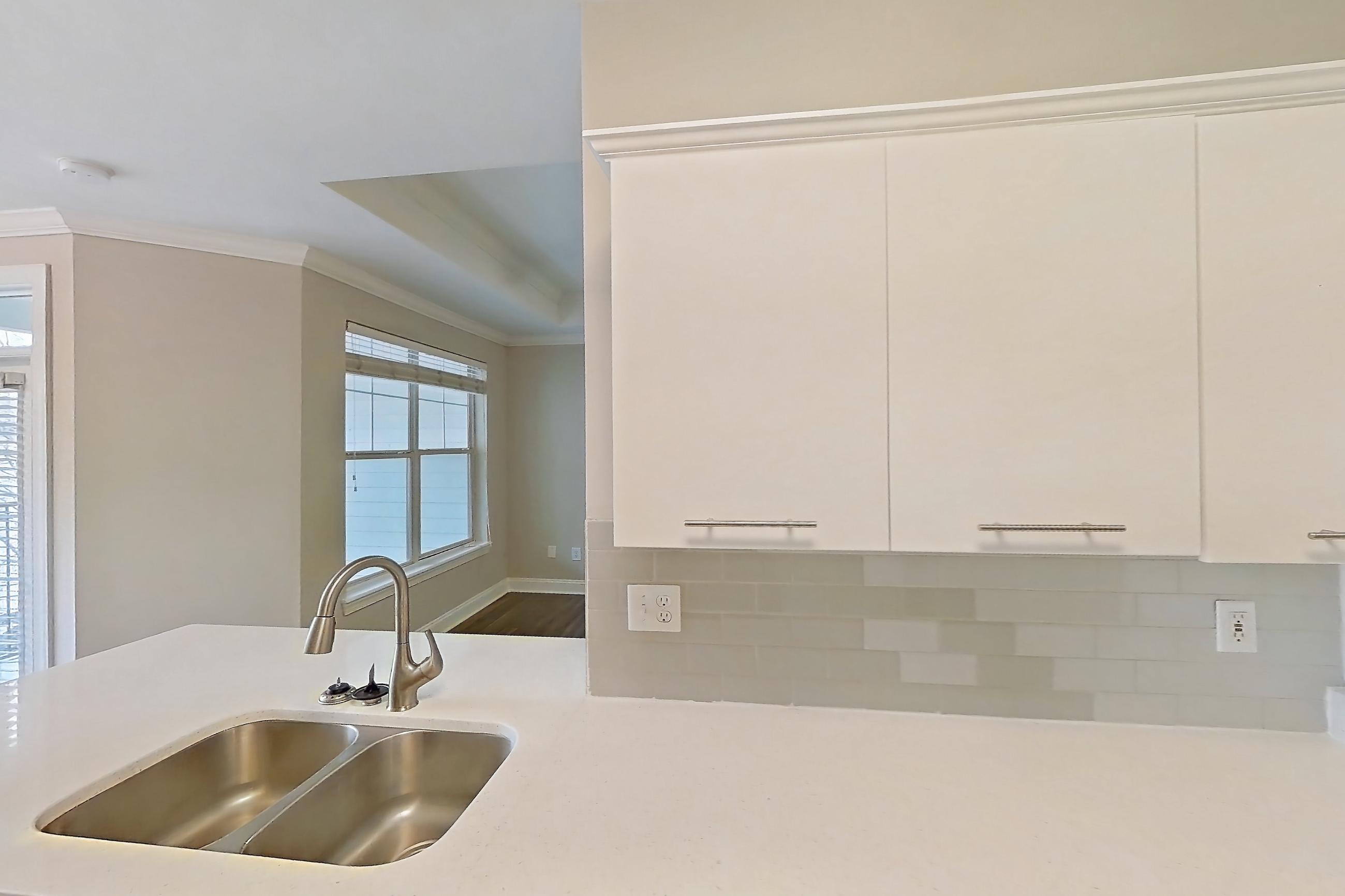 Kitchen with dark wood-finish flooring, dishwasher, electric range, light countertops, light stone countertops, microwave, oven/range, refrigerator, and stainless steel appliances, Apartment 3515 at Marq Perimeter