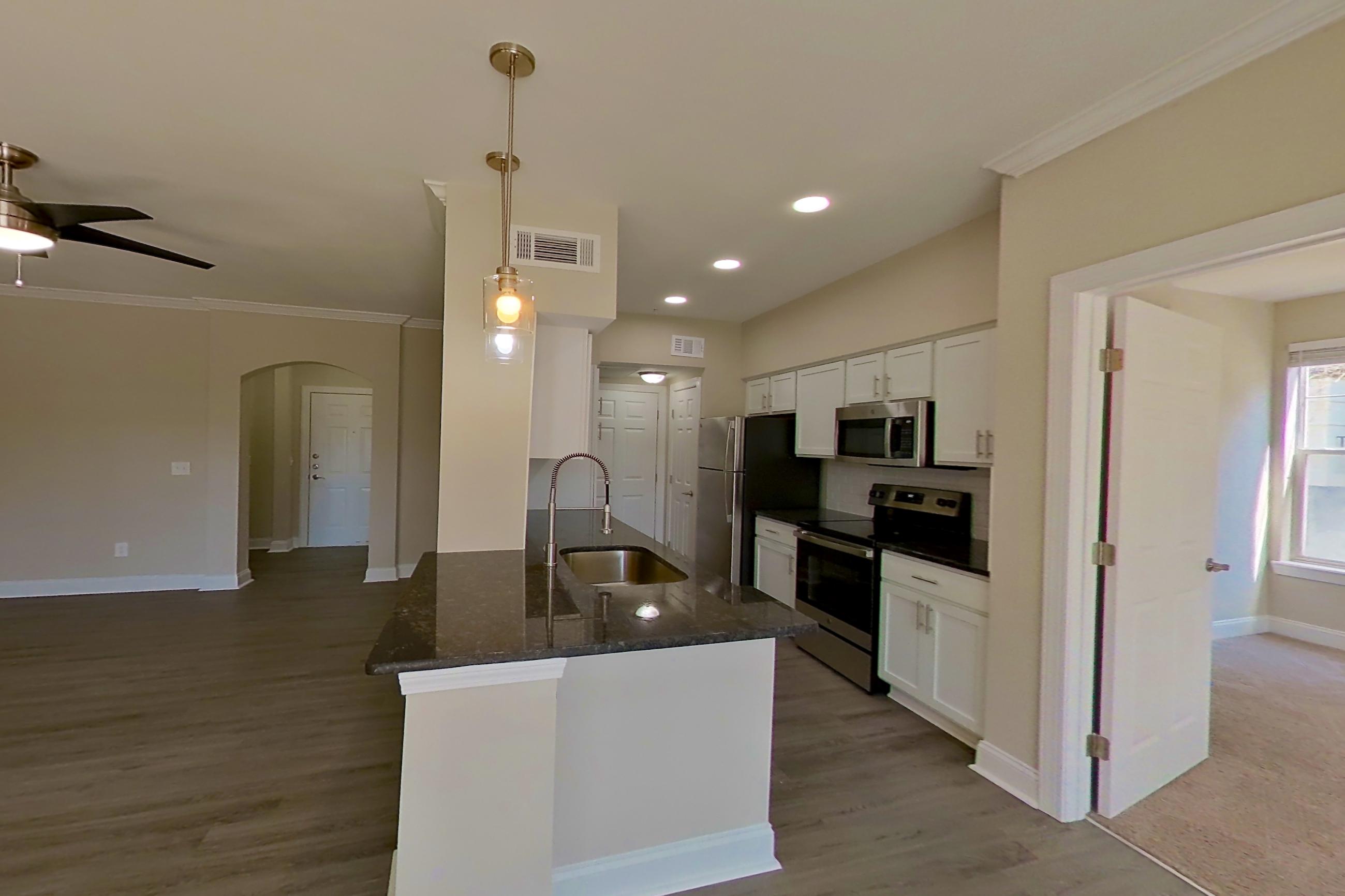 Dining area with dark stone countertops, electric range, light wood-finish flooring, oven/range, and stainless steel appliances, Apartment 4214 at Marq Perimeter