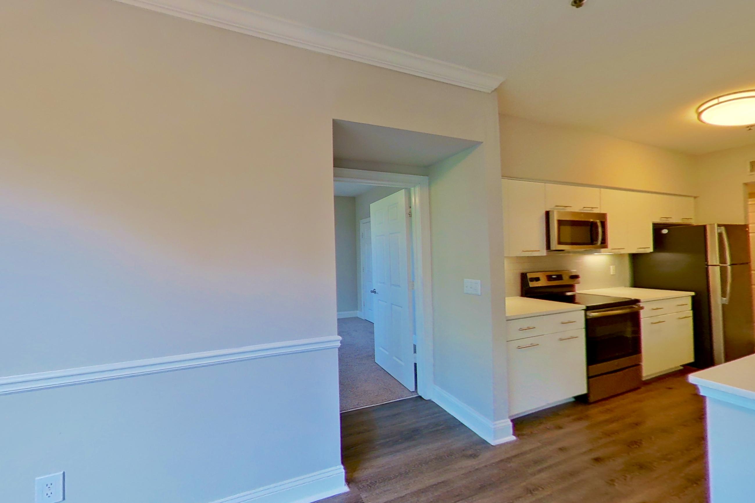 Dining area with dark wood-finish flooring, electric range, light countertops, oven/range, and stainless steel appliances, Apartment 4404 at Marq Perimeter