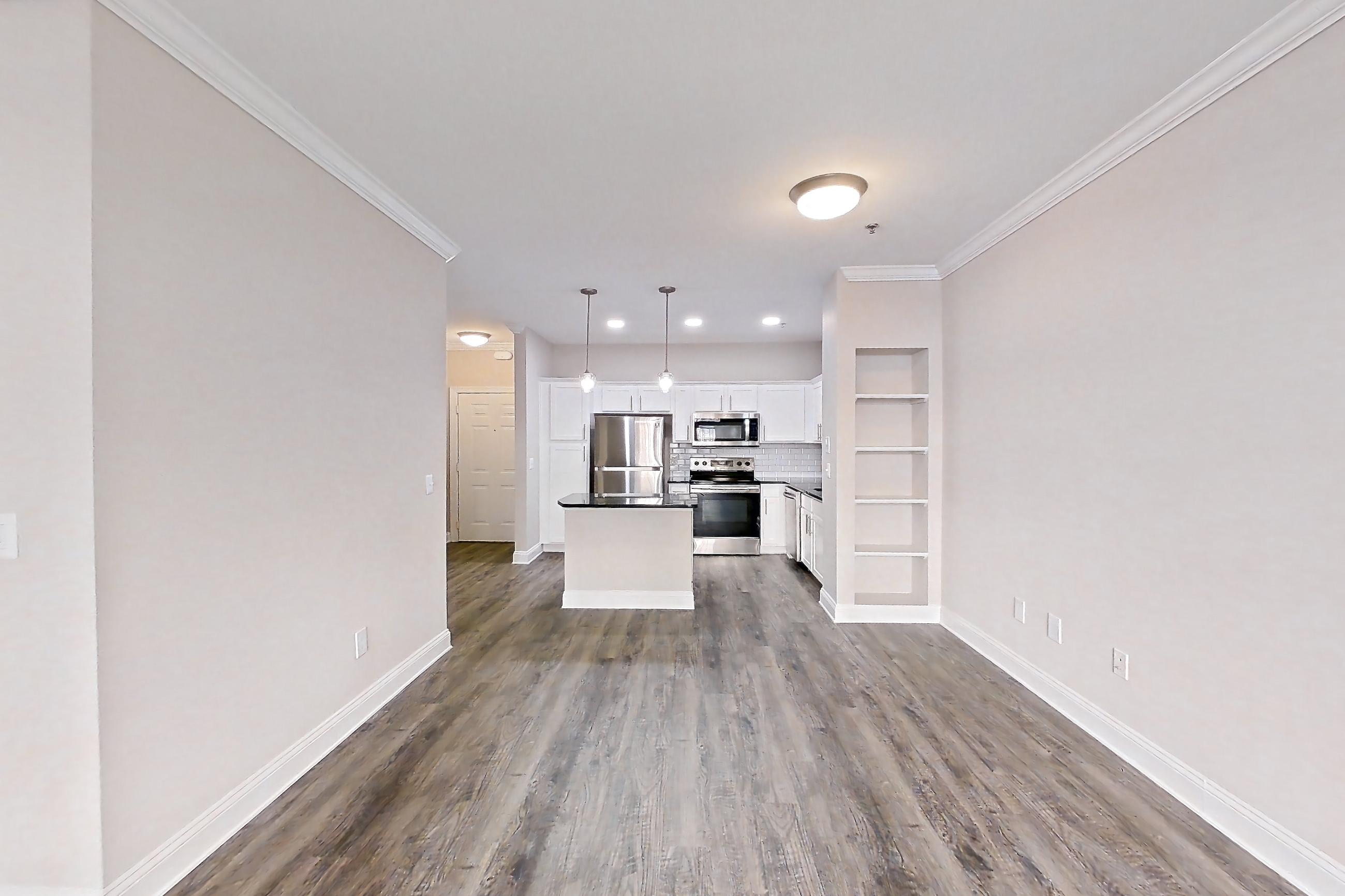 Living room with dark countertops, dark wood-finish flooring, electric range, oven/range, and stainless steel appliances, Apartment 4309 at Marq Perimeter