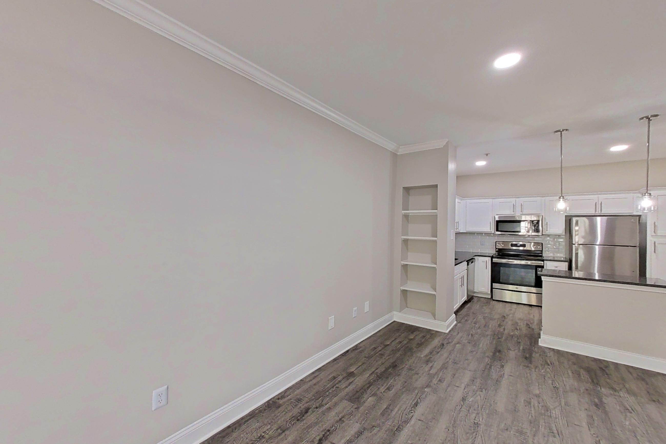 Living room with dark countertops, dark wood-finish flooring, electric range, oven/range, refrigerator, and stainless steel appliances, Apartment 5209 at Marq Perimeter