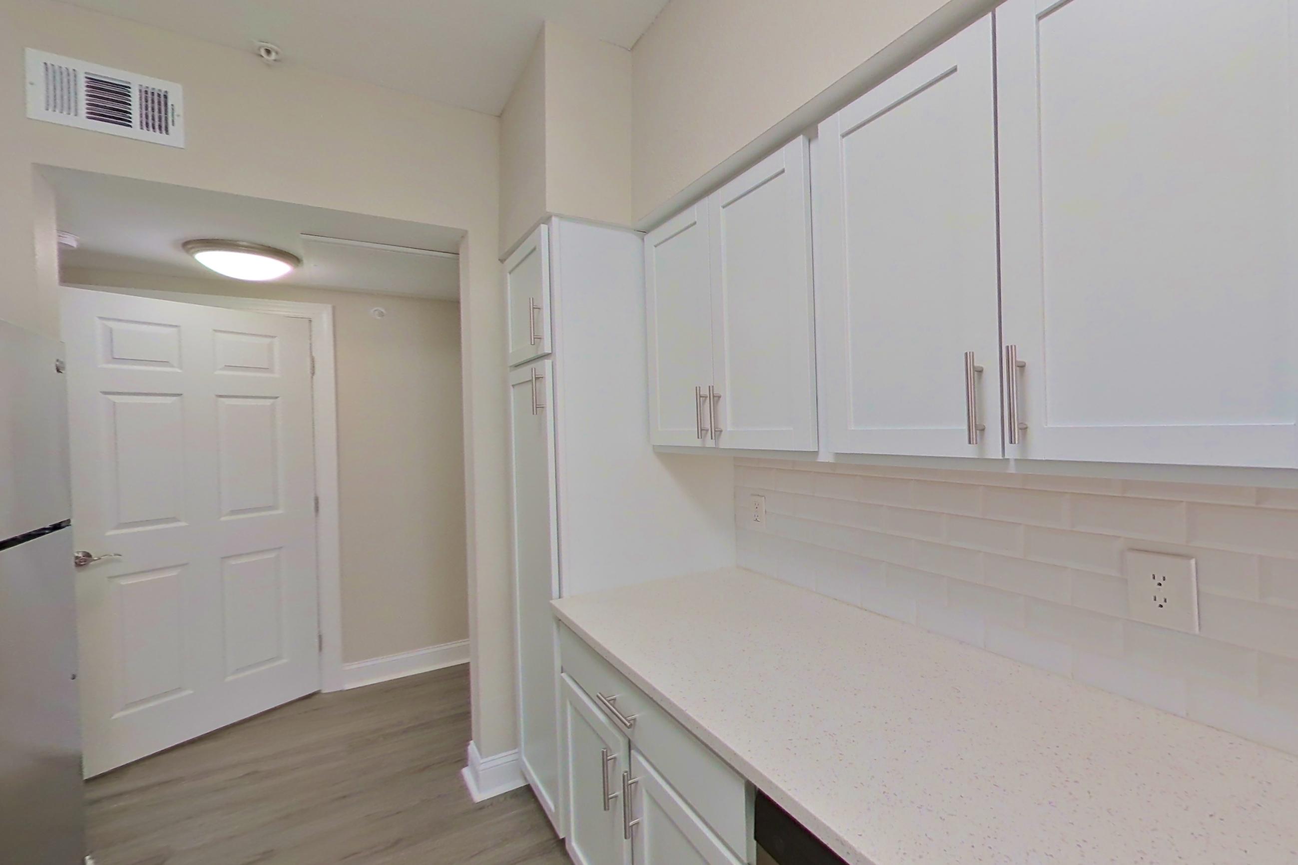 Kitchen with electric range, light countertops, light stone countertops, light wood-finish flooring, oven/range, refrigerator, and stainless steel appliances, Apartment 5412 at Marq Perimeter