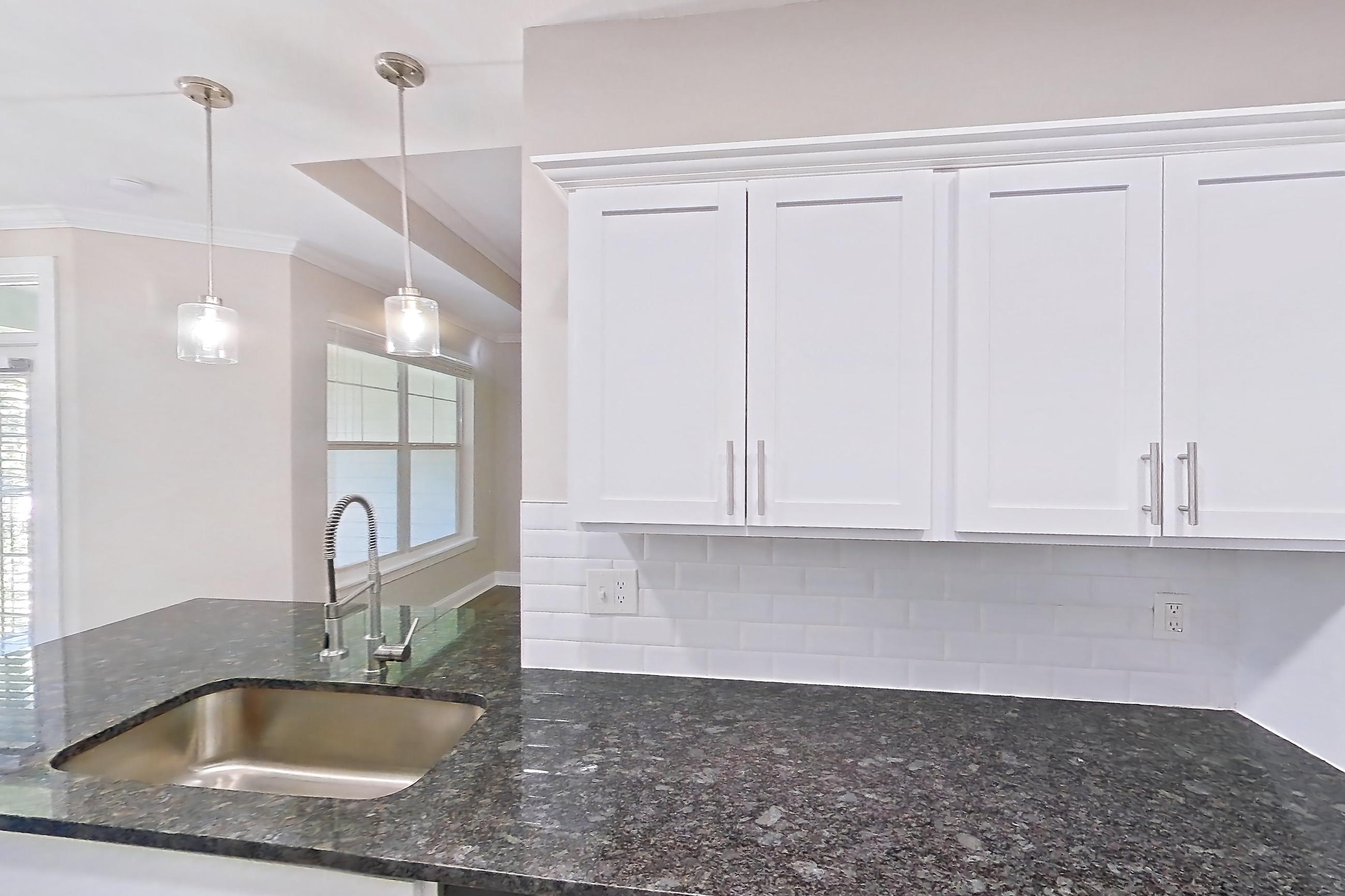 Kitchen with dark stone countertops, dishwasher, electric range, light countertops, light wood-finish flooring, oven/range, refrigerator, and stainless steel appliances, Apartment 5513 at Marq Perimeter