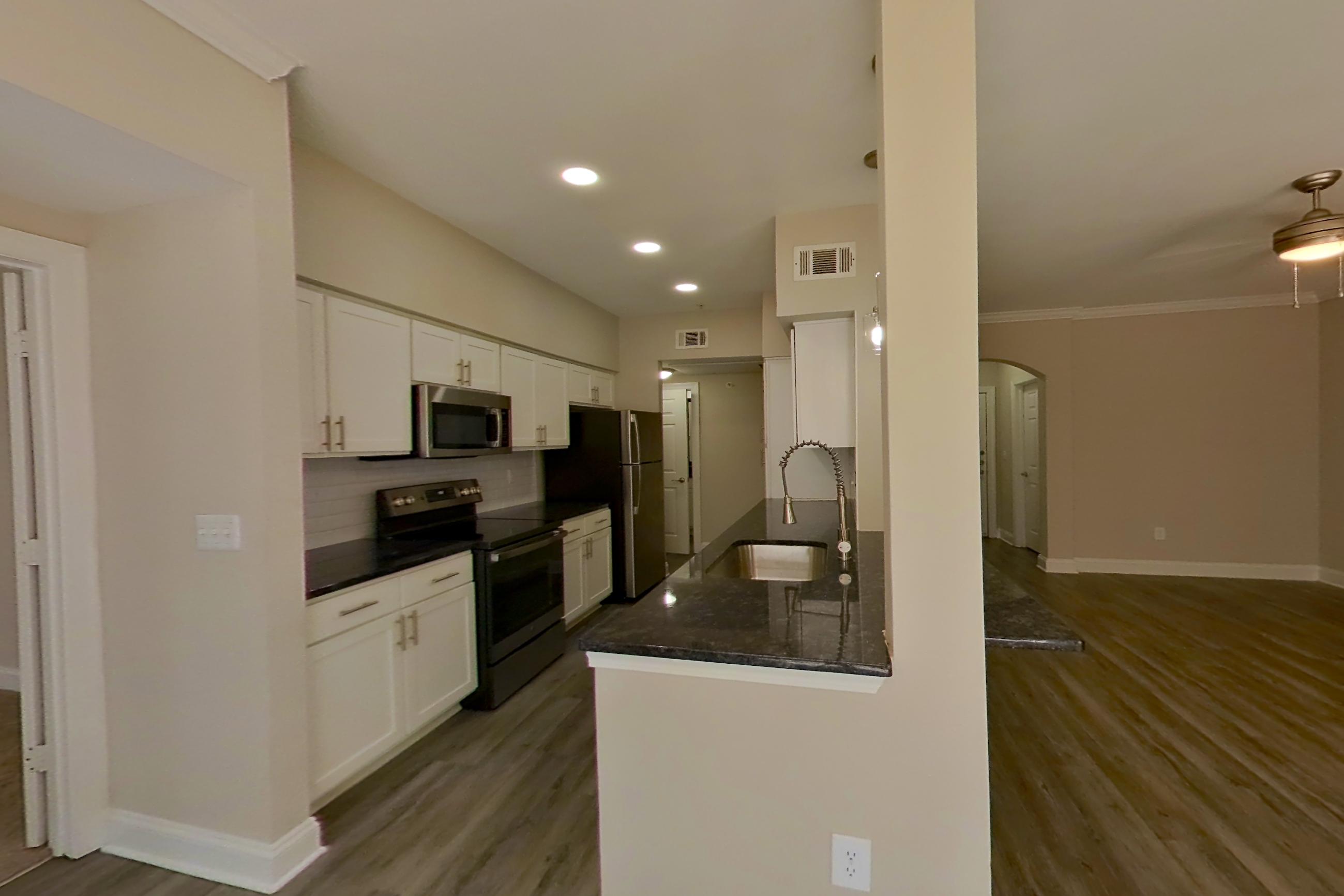 Dining area with dark countertops, electric range, microwave, oven/range, and stainless steel appliances, Apartment 6119 at Marq Perimeter
