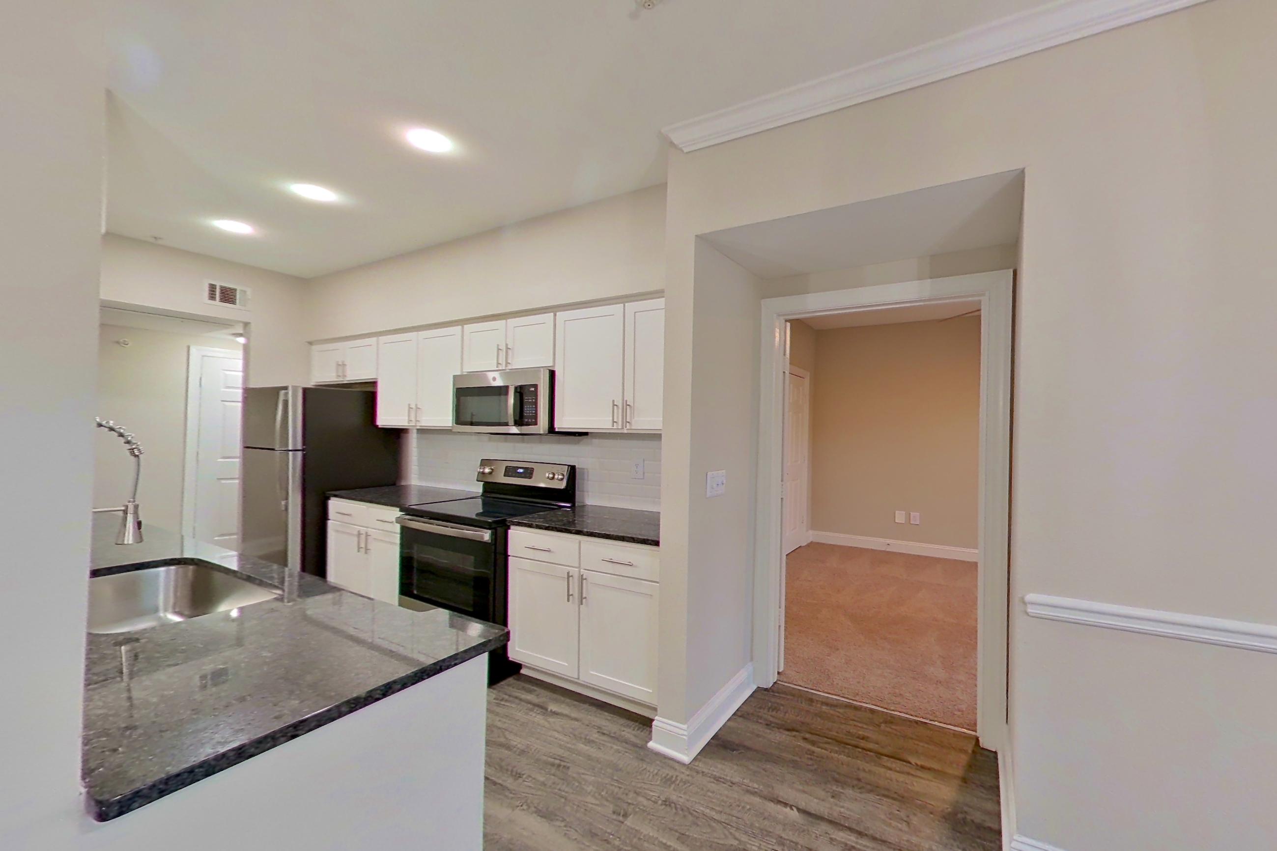 Dining area with dark stone countertops, electric range, microwave, oven/range, and stainless steel appliances, Apartment 6134 at Marq Perimeter