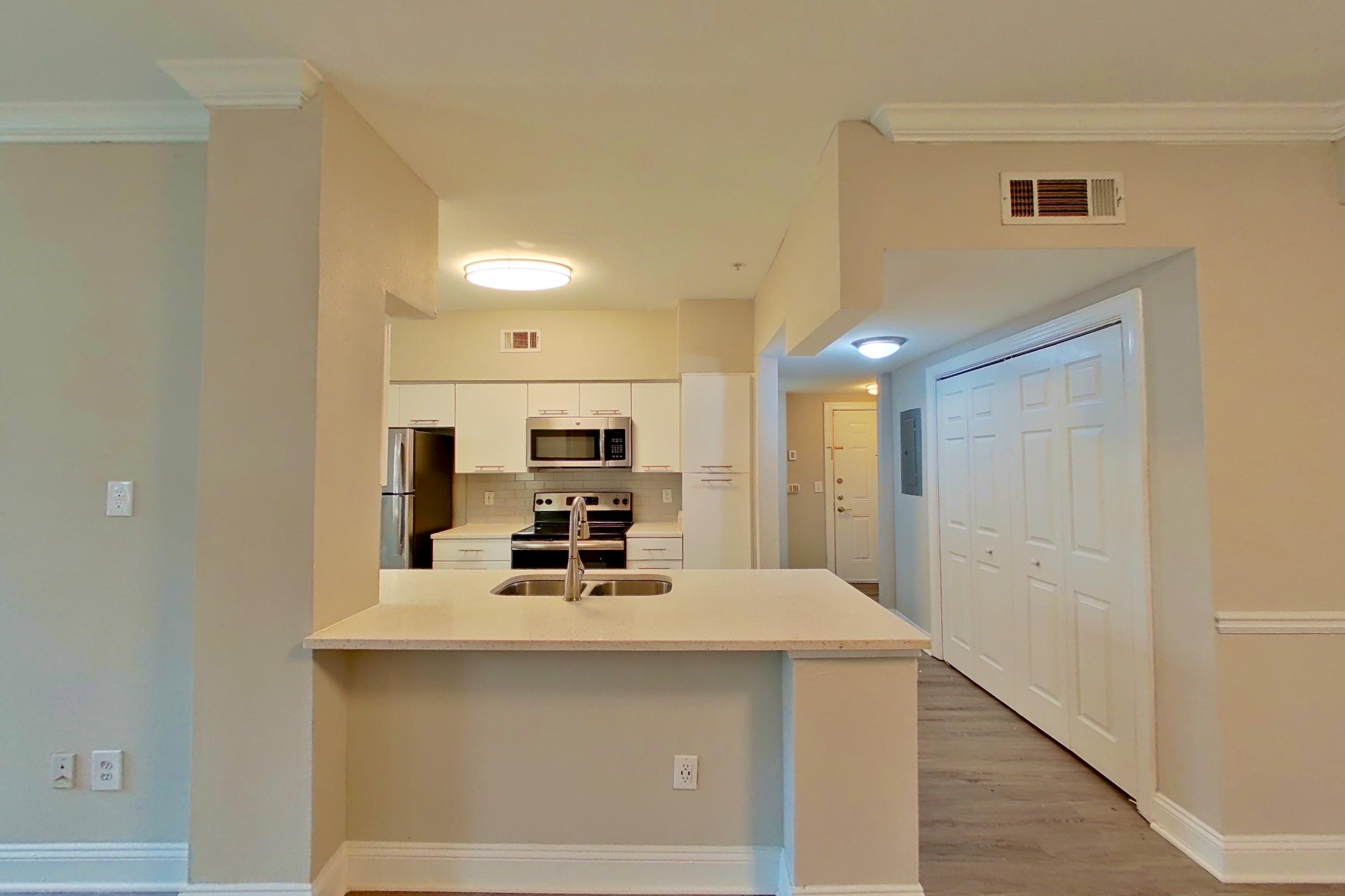 Dining area with electric range, light countertops, light wood-finish flooring, oven/range, refrigerator, and stainless steel appliances, Apartment 6235 at Marq Perimeter