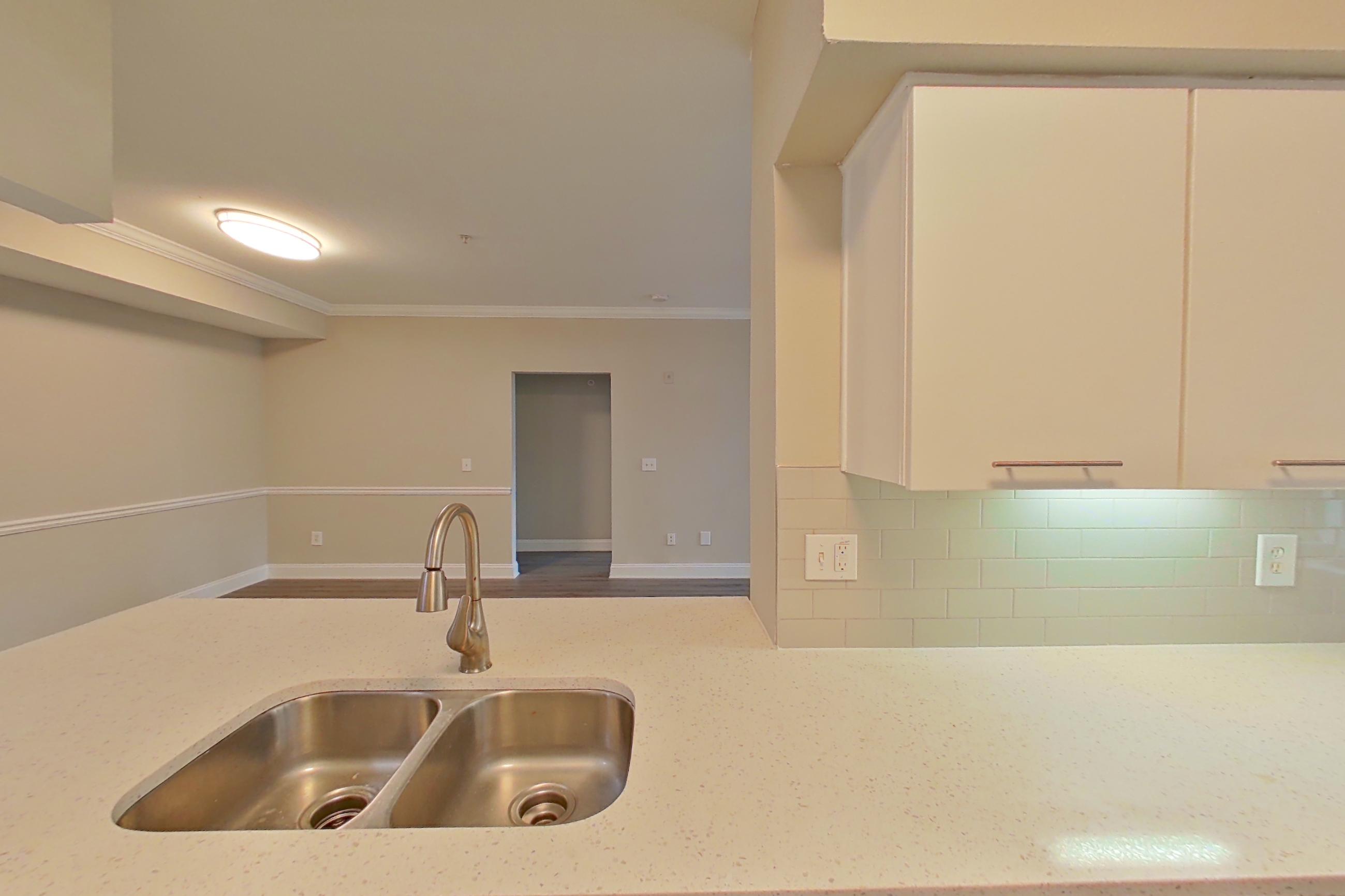 Kitchen with dishwasher, electric range, light stone countertops, light vinyl flooring, light wood-finish flooring, microwave, oven/range, refrigerator, and stainless steel appliances, Apartment 6235 at Marq Perimeter