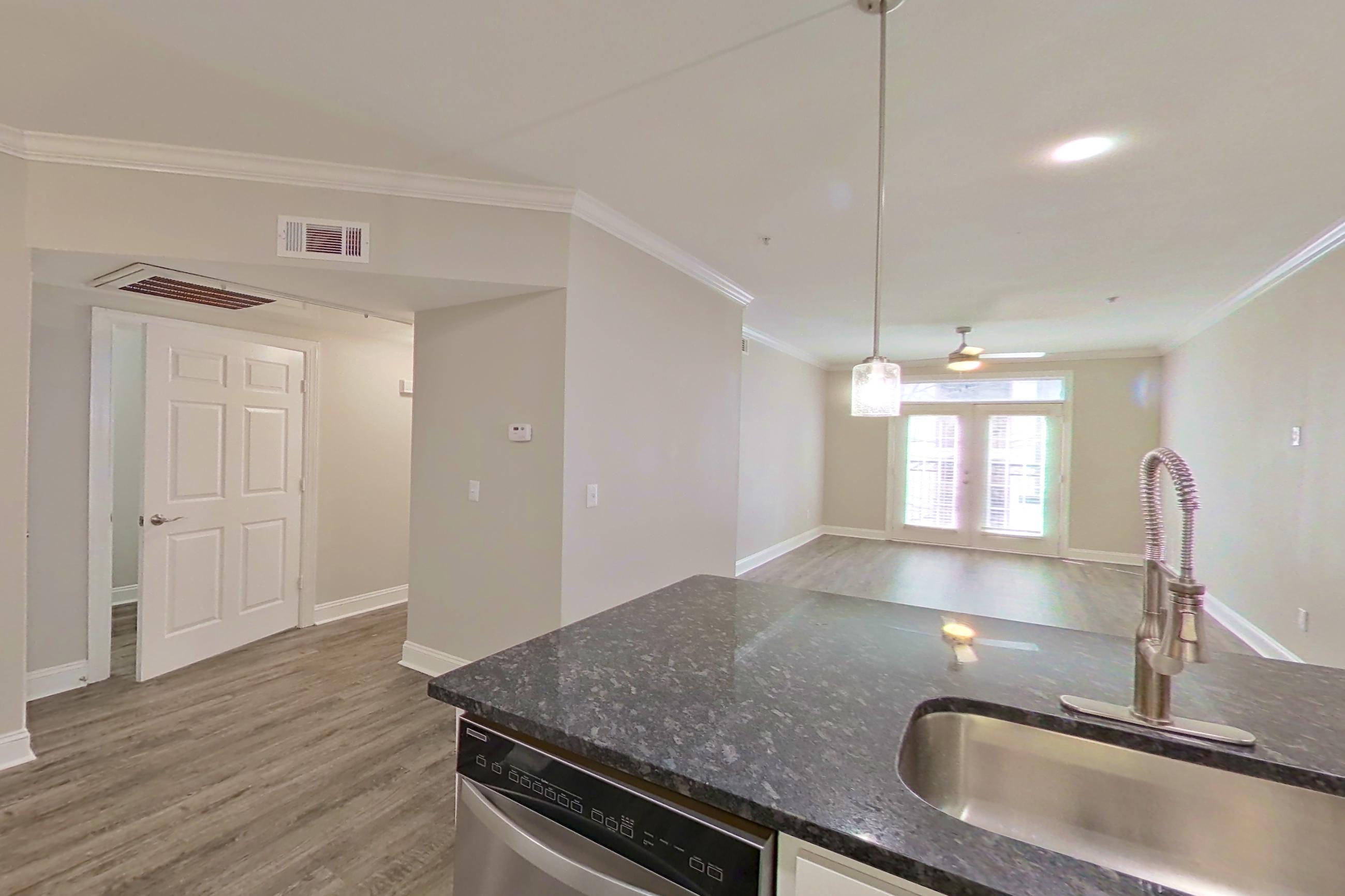 Kitchen with dark stone countertops, dishwasher, electric range, light countertops, microwave, oven/range, refrigerator, and stainless steel appliances, Apartment 6303 at Marq Perimeter