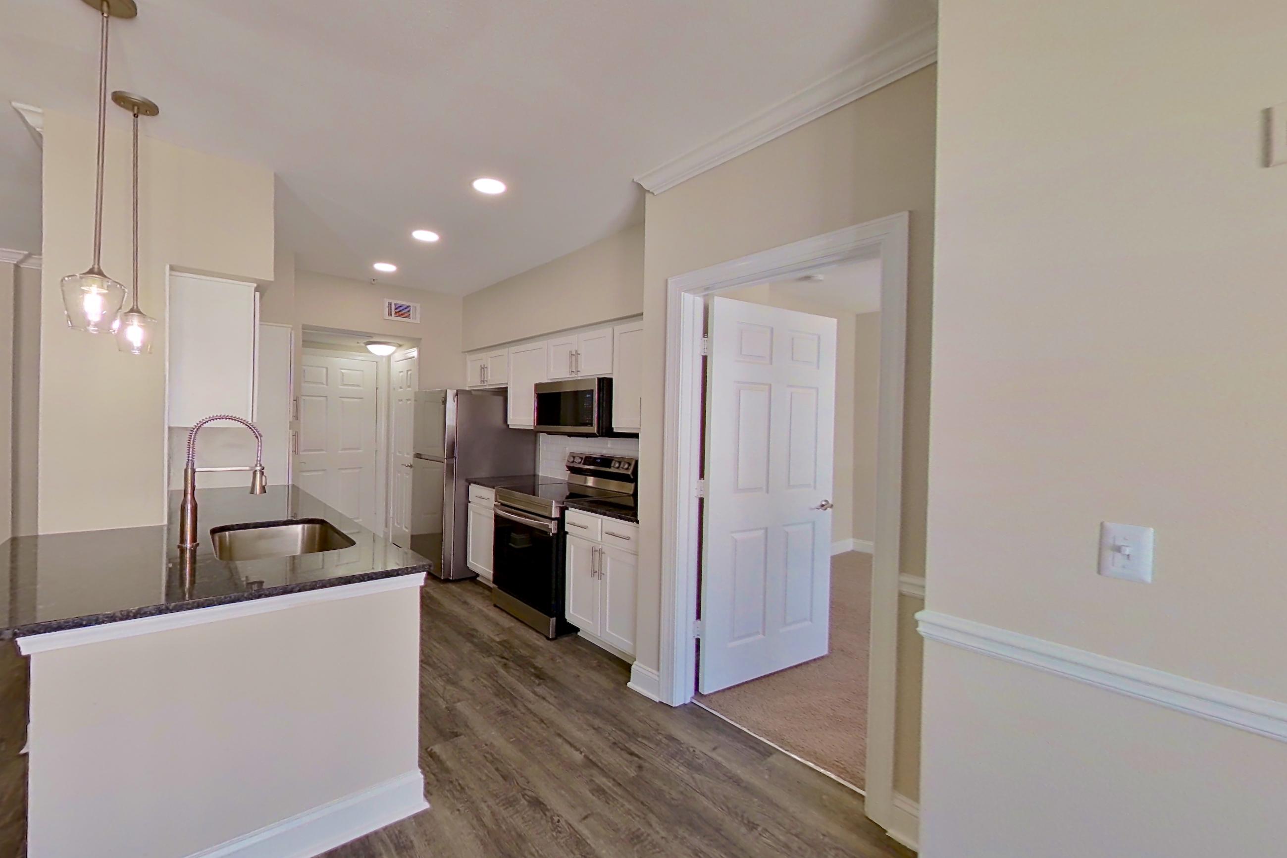Dining area with dark countertops, dark wood-finish flooring, electric range, oven/range, and stainless steel appliances, Apartment 6320 at Marq Perimeter
