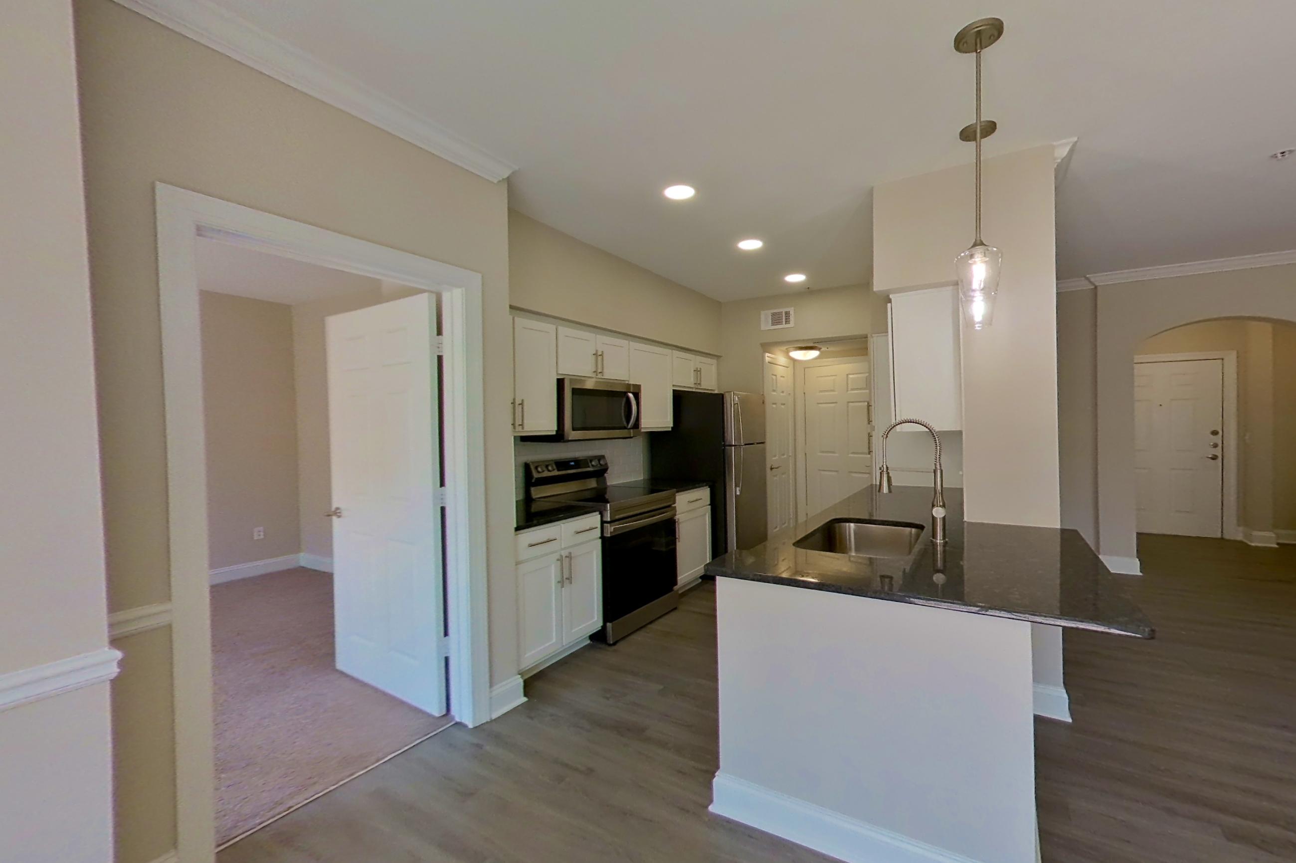 Dining area with dark countertops, electric range, light wood-finish flooring, oven/range, and stainless steel appliances, Apartment 6321 at Marq Perimeter