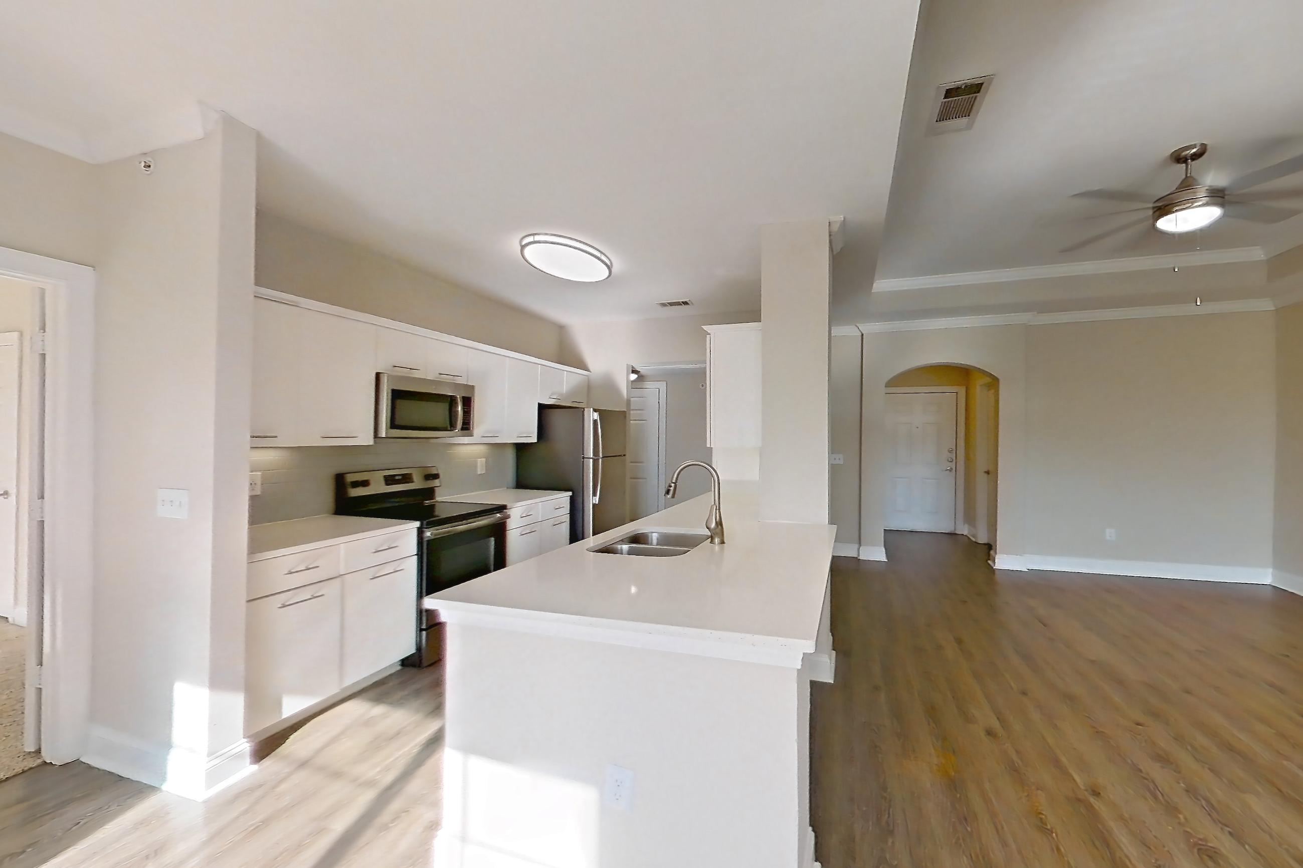Dining room with electric range, light countertops, light wood-finish flooring, microwave, oven/range, refrigerator, and stainless steel appliances, Apartment 6425 at Marq Perimeter