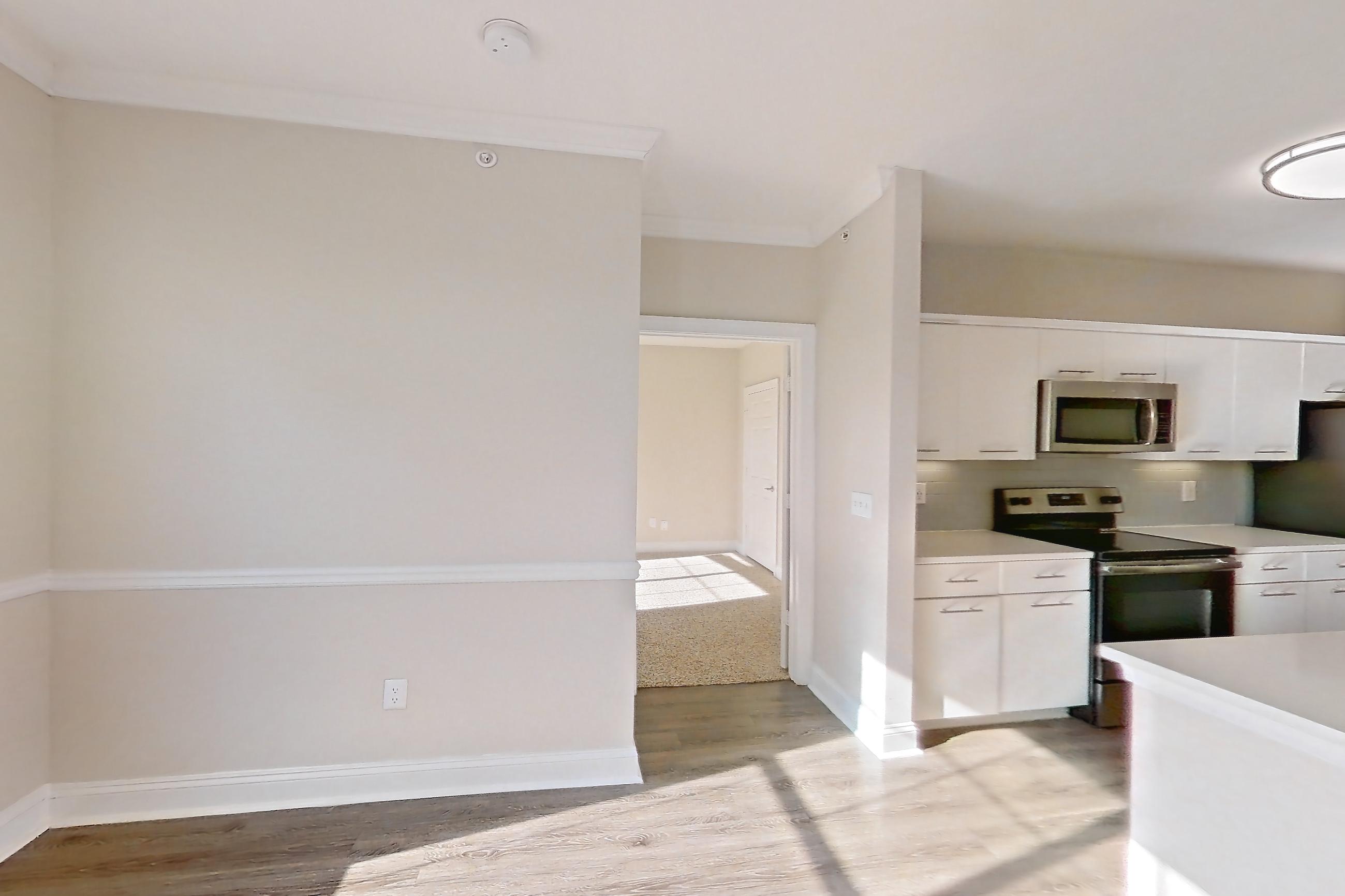 Dining room with electric range, light countertops, light wood-finish flooring, microwave, oven/range, refrigerator, and stainless steel appliances, Apartment 6425 at Marq Perimeter