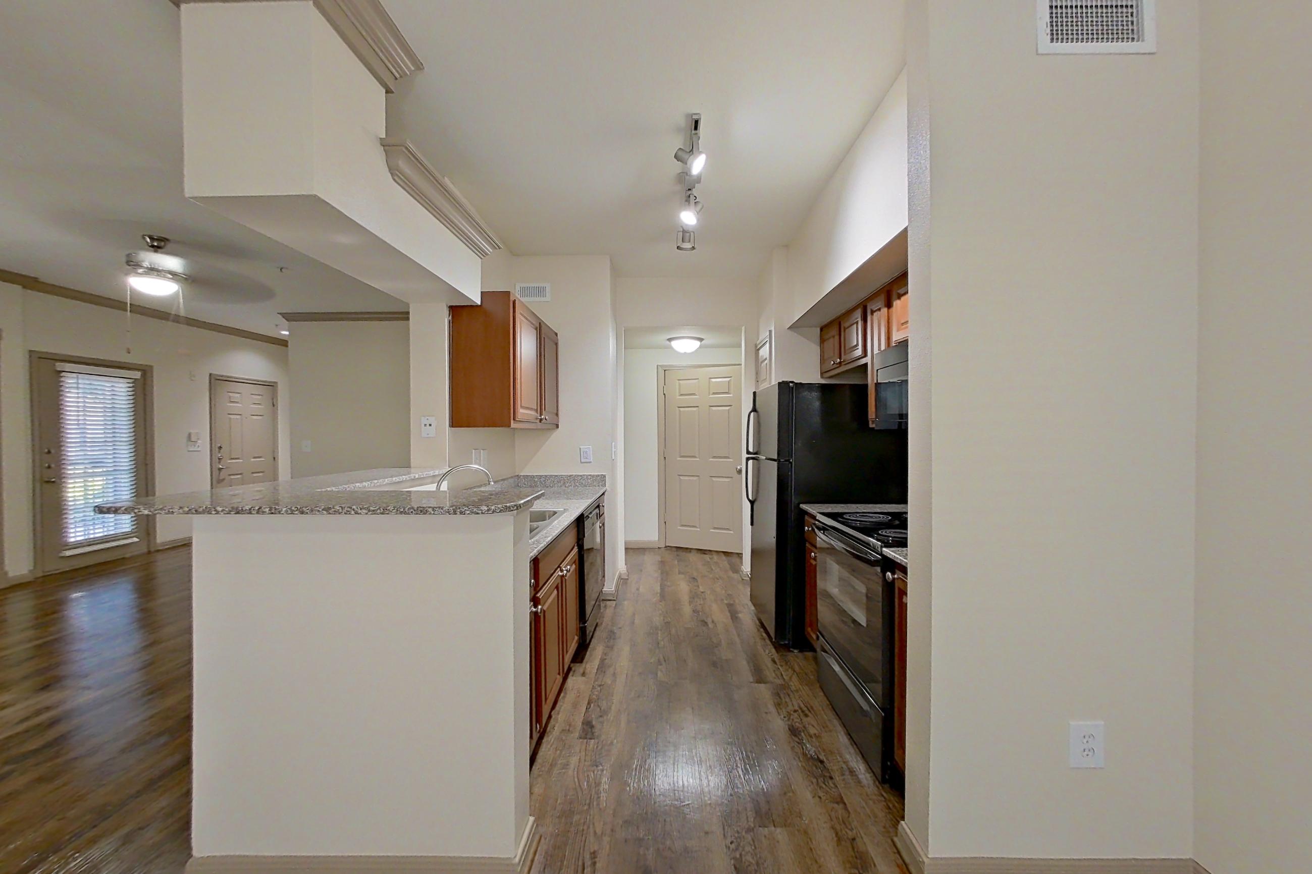Dining room with black appliances, dark wood-finish flooring, dishwasher, electric range, kitchen island, light stone countertops, oven/range, and refrigerator, Apartment 0618 at Marquis on Park Row