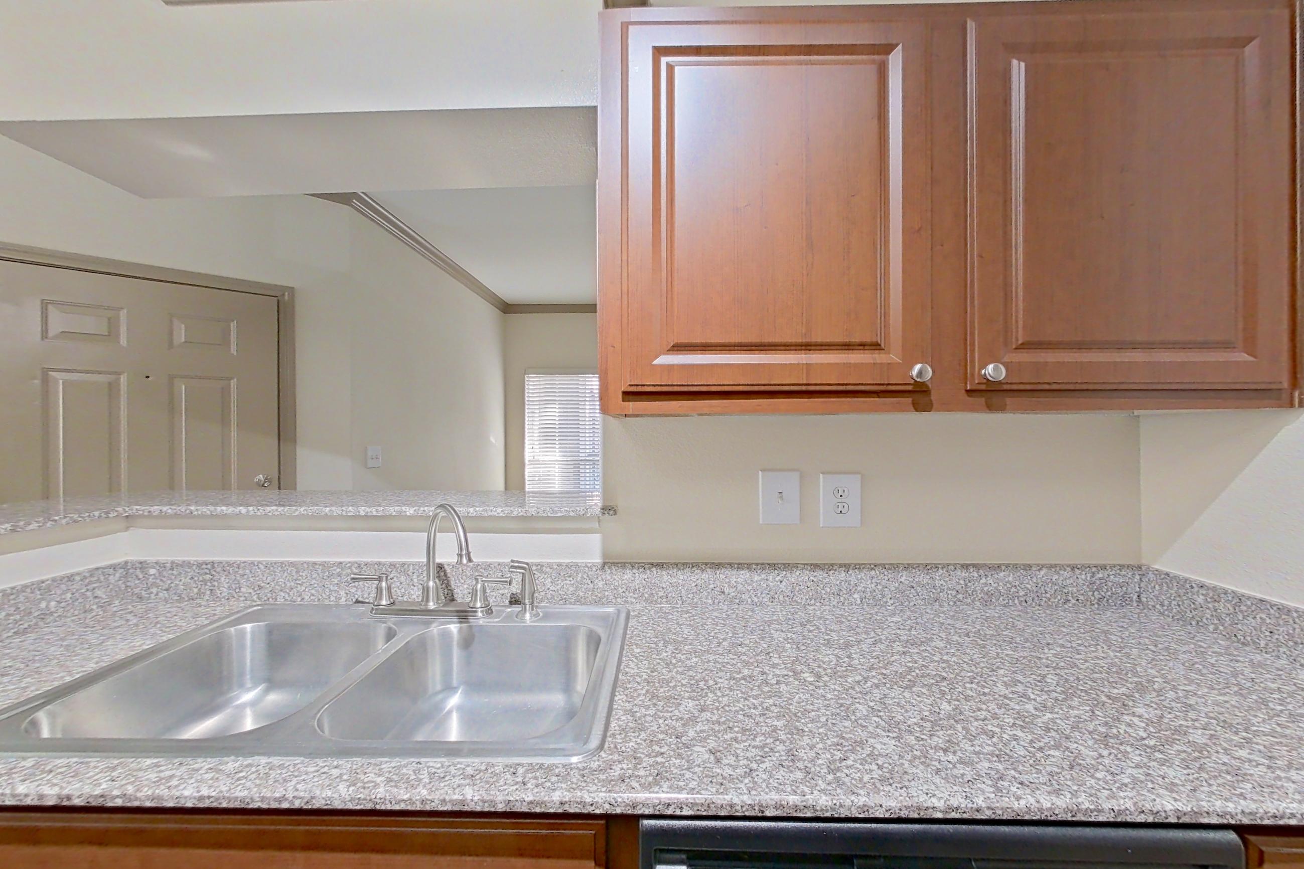 Kitchen with black appliances, dishwasher, electric range, light countertops, light stone countertops, light wood-finish flooring, microwave, oven/range, and refrigerator, Apartment 0618 at Marquis on Park Row