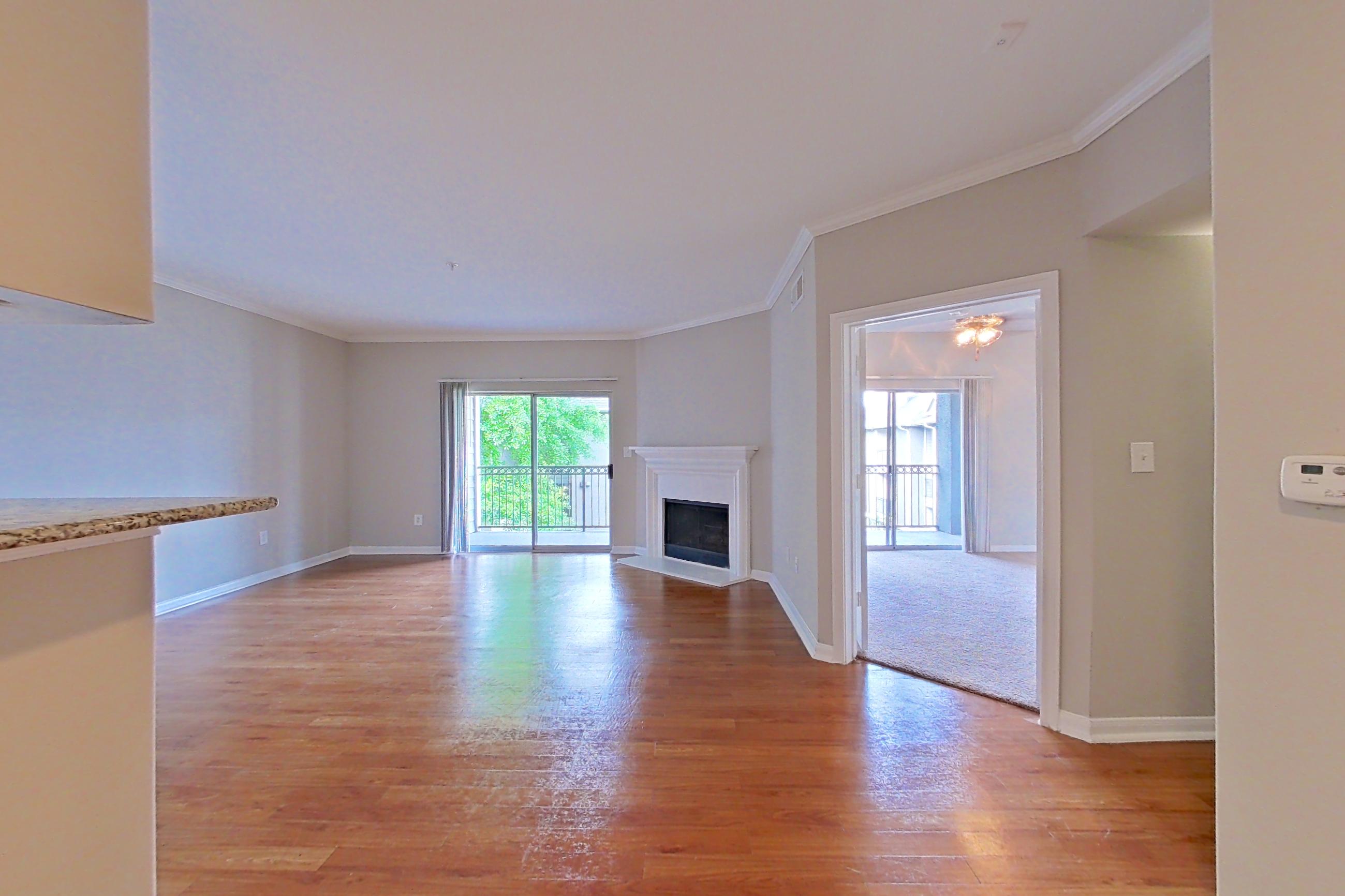 Dining room with black appliances, electric range, fireplace, light stone countertops, light wood-finish flooring, and oven/range, Apartment 0137 at Marquis on Westheimer