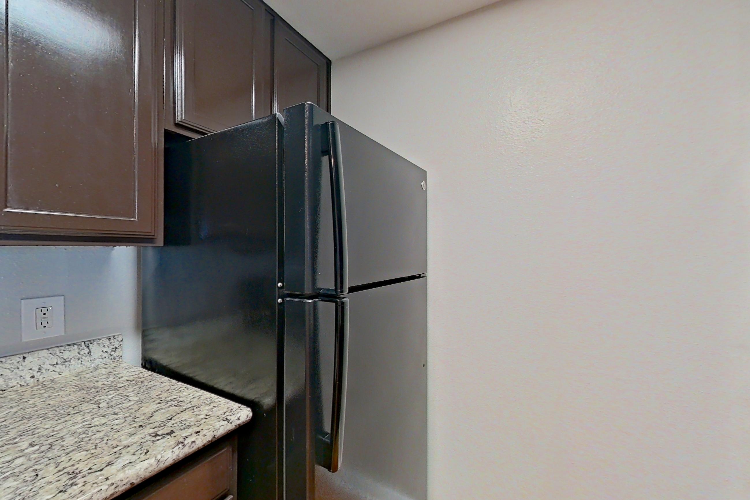 Kitchen with black appliances, electric range, light stone countertops, light wood-finish flooring, oven/range, and refrigerator, Apartment 0137 at Marquis on Westheimer