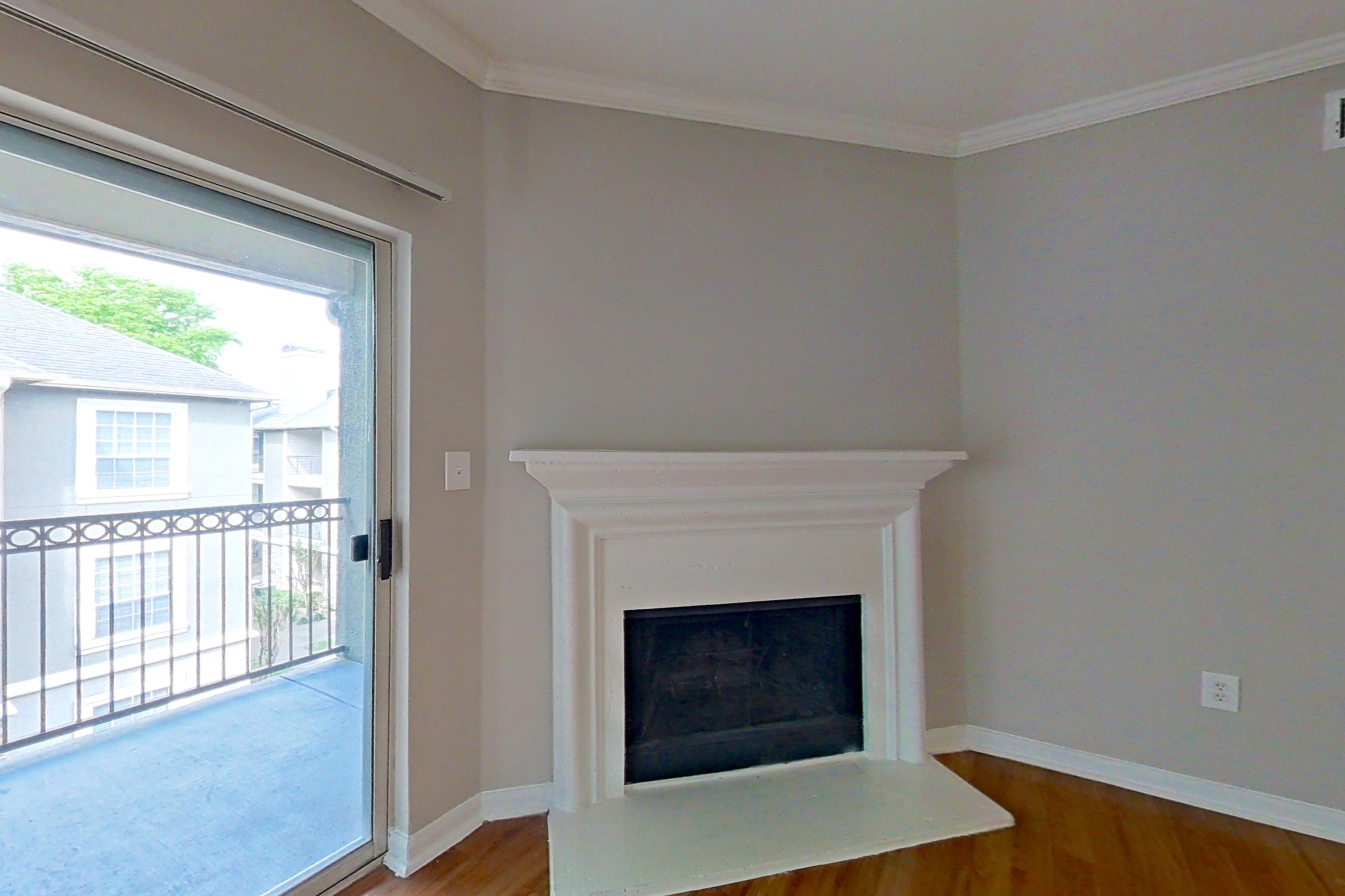Living room with fireplace and light wood-finish flooring, Apartment 0137 at Marquis on Westheimer