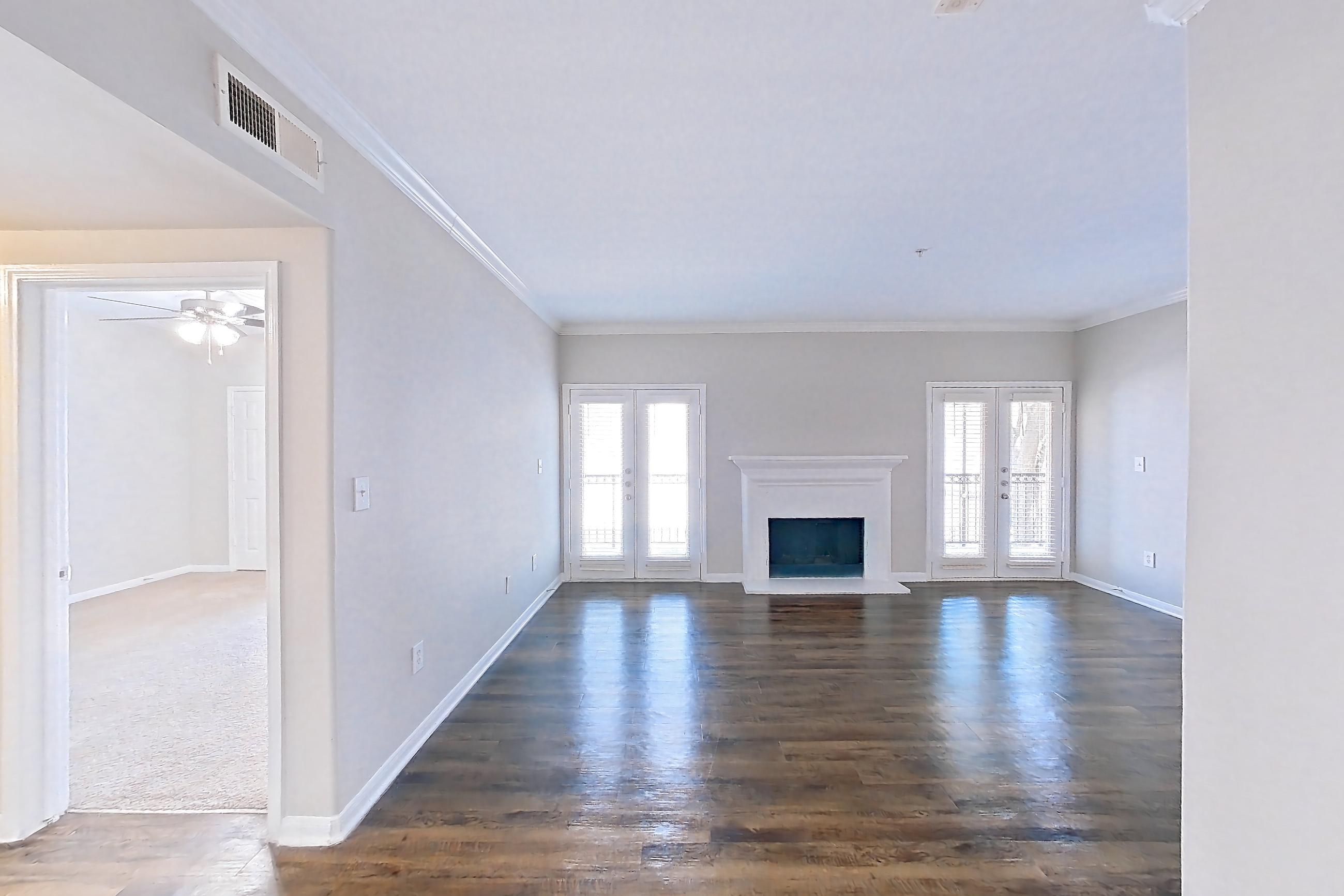 Dining room with black appliances, electric range, fireplace, light countertops, light stone countertops, light wood-finish flooring, oven/range, and refrigerator, Apartment 0323 at Marquis on Westheimer