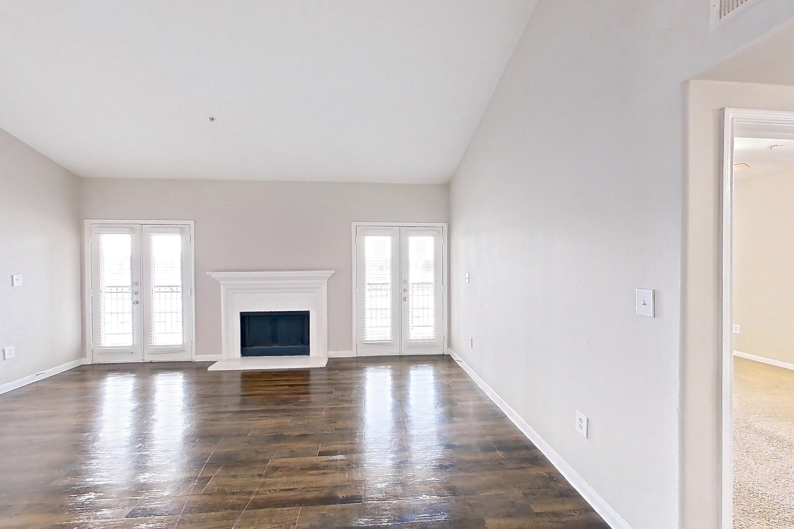 Dining room with black appliances, dark wood-finish flooring, electric range, fireplace, light stone countertops, light wood-finish flooring, oven/range, and refrigerator, Apartment 0336 at Marquis on Westheimer