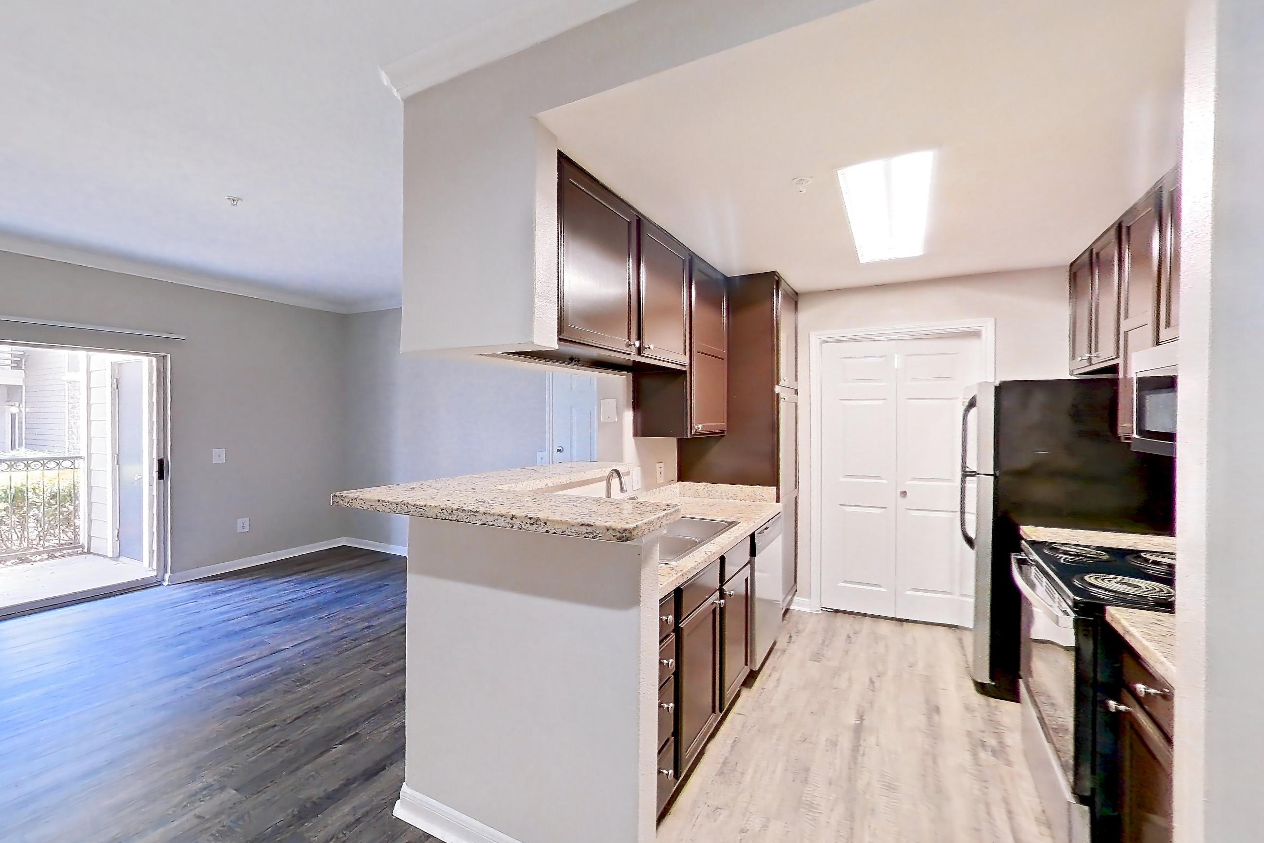Dining room with dark wood-finish flooring, dishwasher, electric range, light stone countertops, light wood-finish flooring, oven/range, refrigerator, stainless steel appliances, and white appliances, Apartment 0414 at Marquis on Westheimer