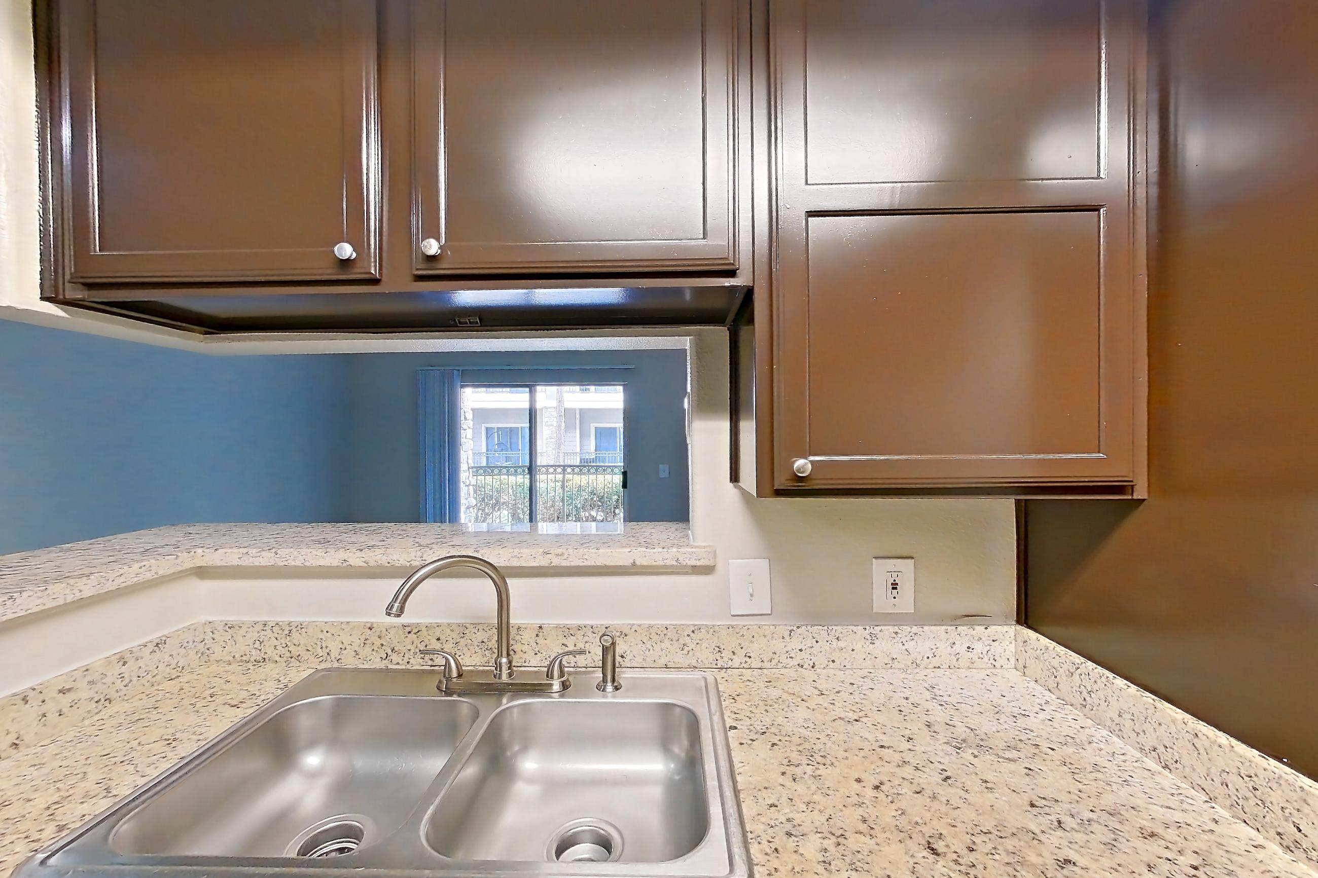 Kitchen with dishwasher, electric range, light stone countertops, light wood-finish flooring, oven/range, refrigerator, stainless steel appliances, and white appliances, Apartment 0414 at Marquis on Westheimer
