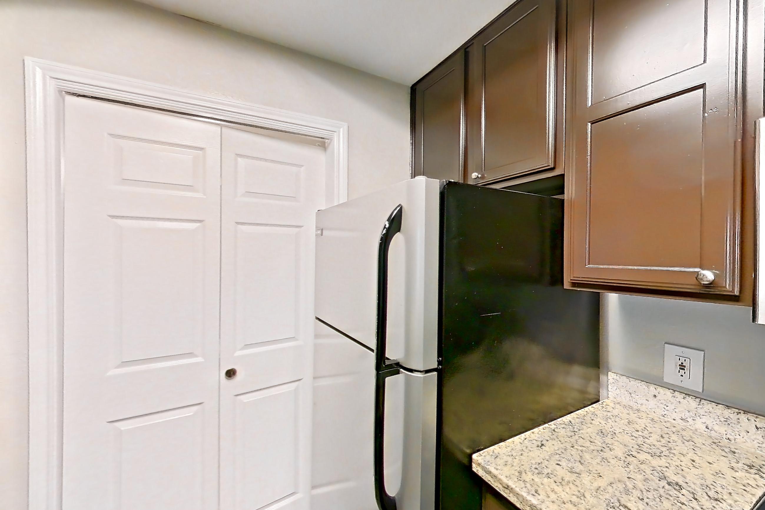 Kitchen with dishwasher, electric range, light stone countertops, light wood-finish flooring, oven/range, refrigerator, stainless steel appliances, and white appliances, Apartment 0414 at Marquis on Westheimer
